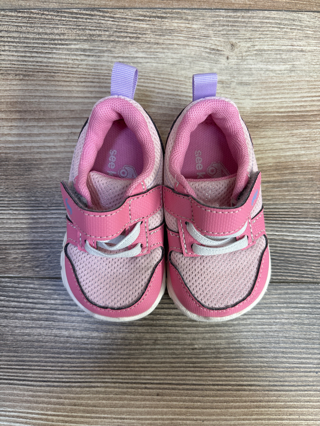 Top view of See Kai Run Basics Tenny sneakers, pink mesh with Velcro strap and elastic laces on wood floor