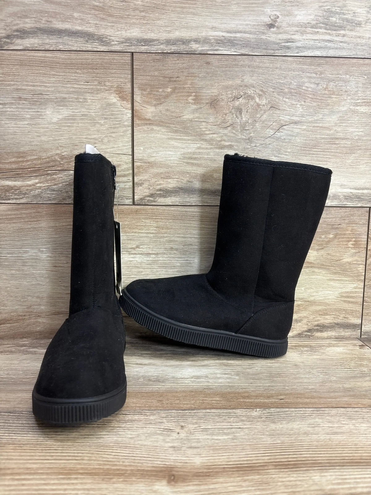 Front and side view of Cat & Jack Natalia kids tall shearling boots in black, faux suede upper and rubber sole on wood floor