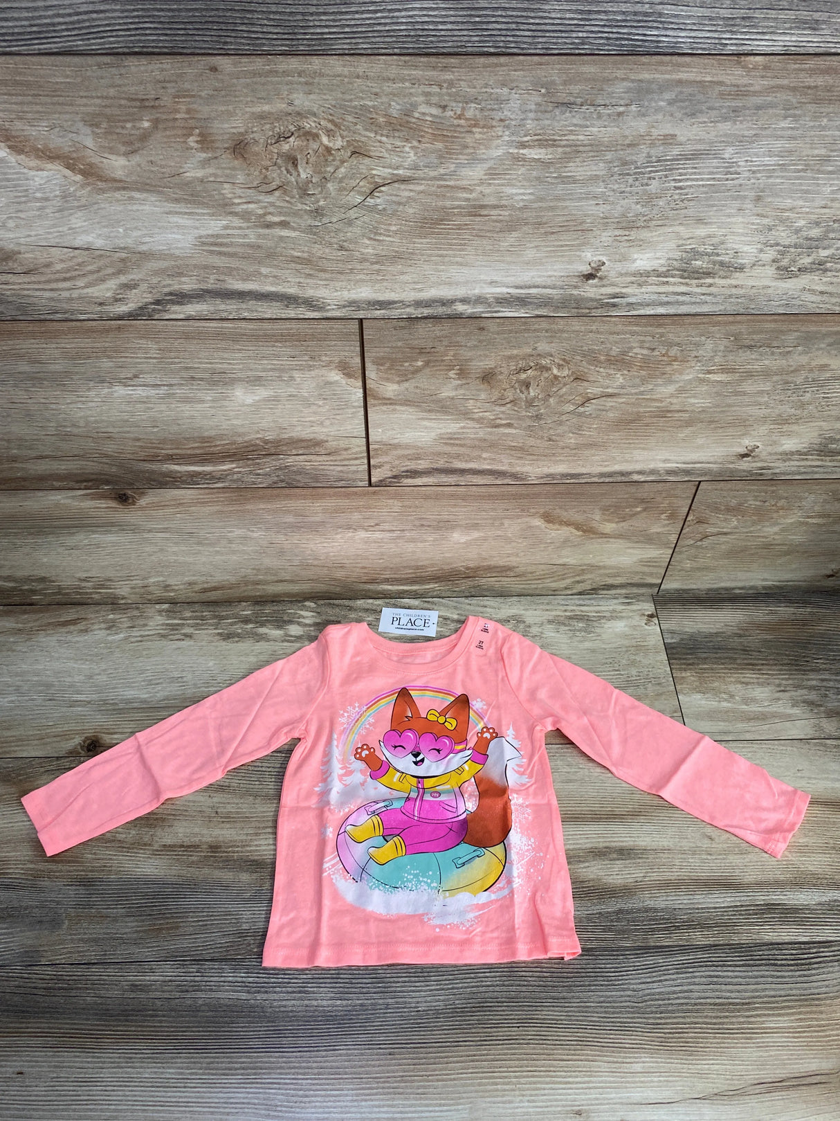 Pink long sleeve toddler shirt with playful fox wearing heart-shaped glasses tubing on snow