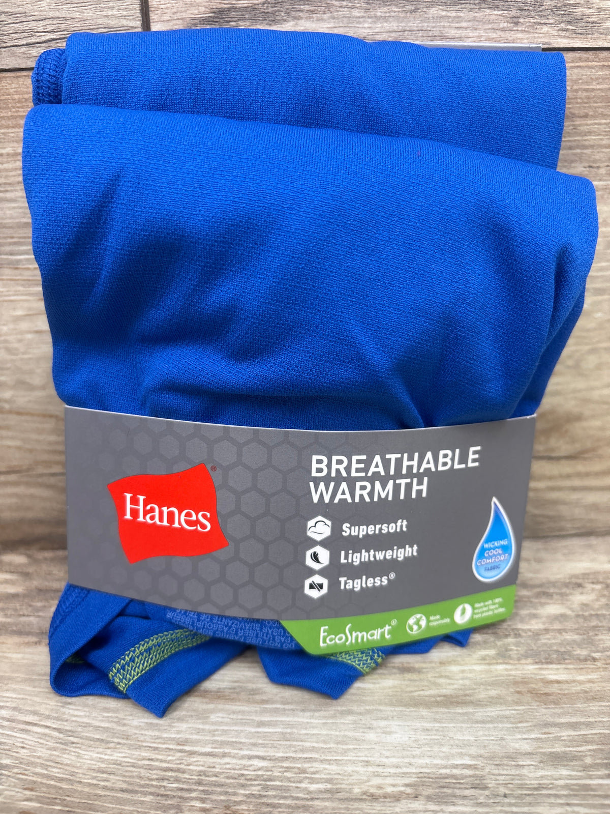 Top view of Hanes blue two piece crew and pant set, size large 14 to 16, showing breathable warmth and tagless fabric on wood grain