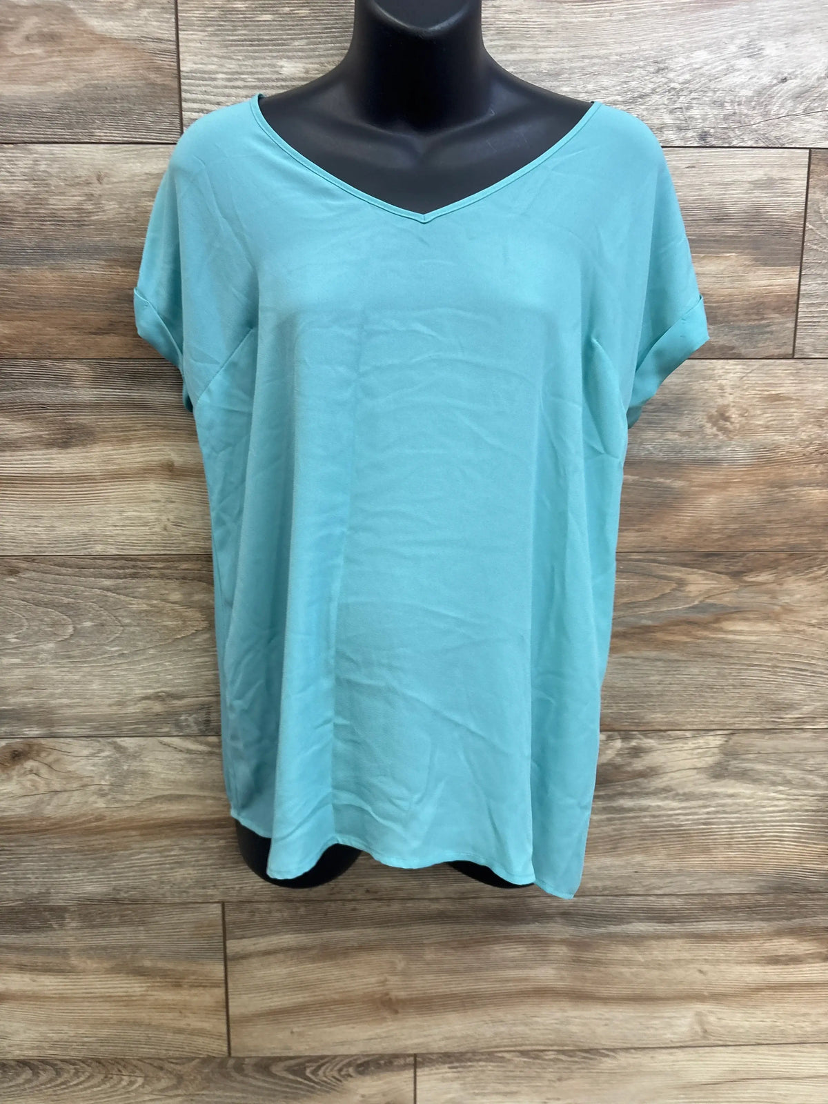 Front view of teal Motherhood Maternity shirt in size Small showcasing v-neck and relaxed fit on black mannequin