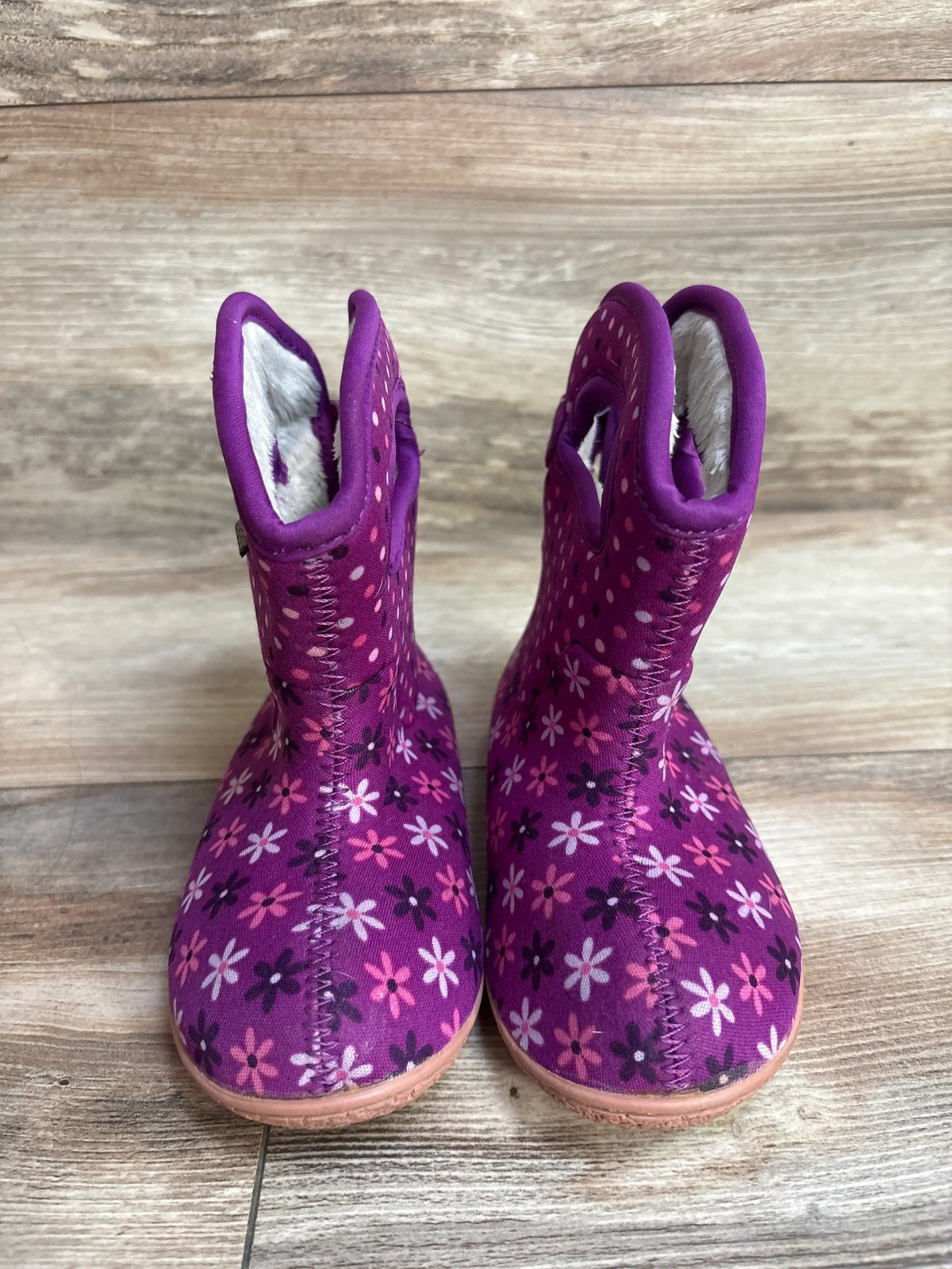 Purple floral toddler boots with pink and white flowers on wooden floor