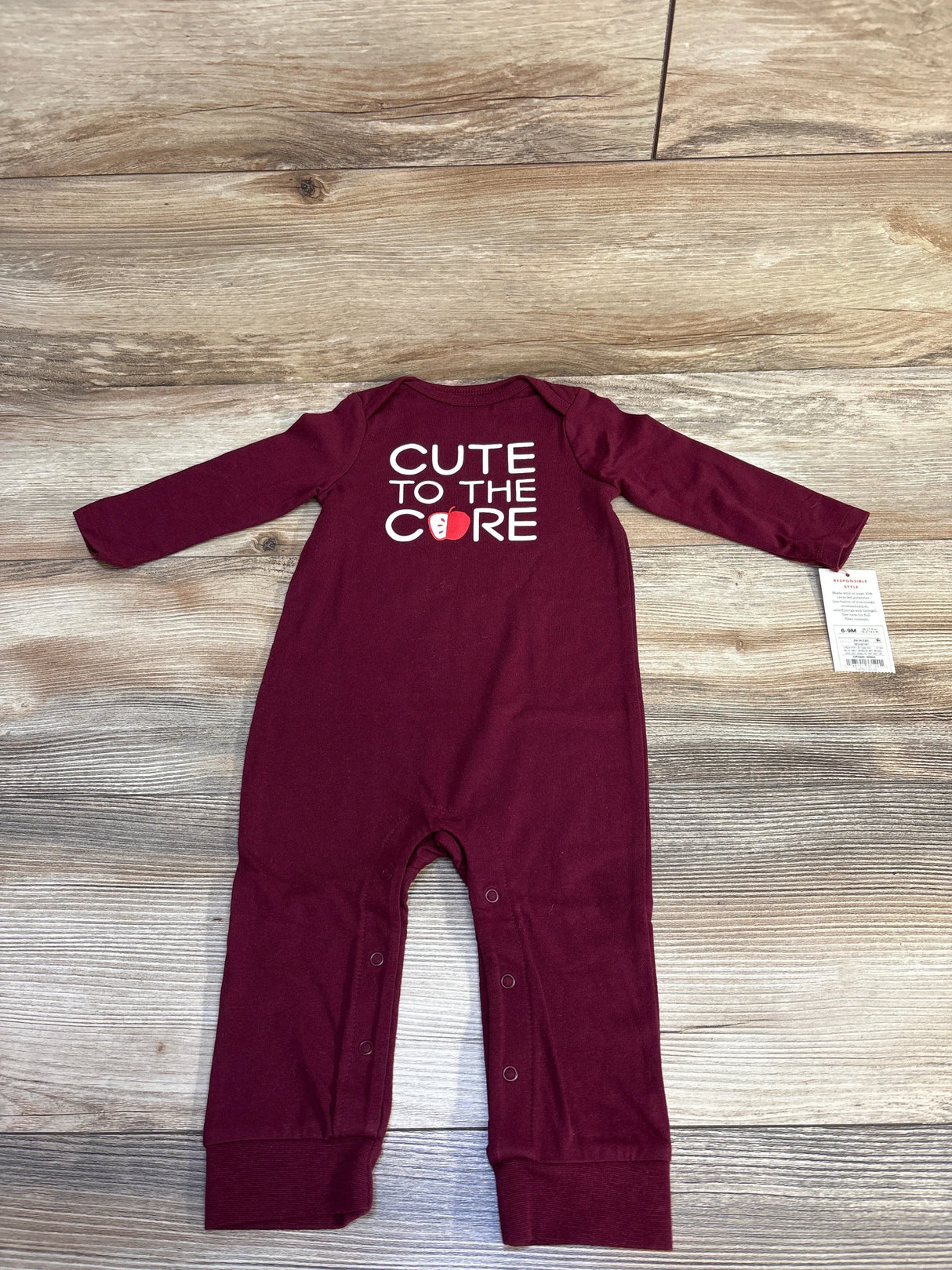 Maroon baby romper with long sleeves and text 'Cute to the Core' with apple graphic on back, size 6-9 months