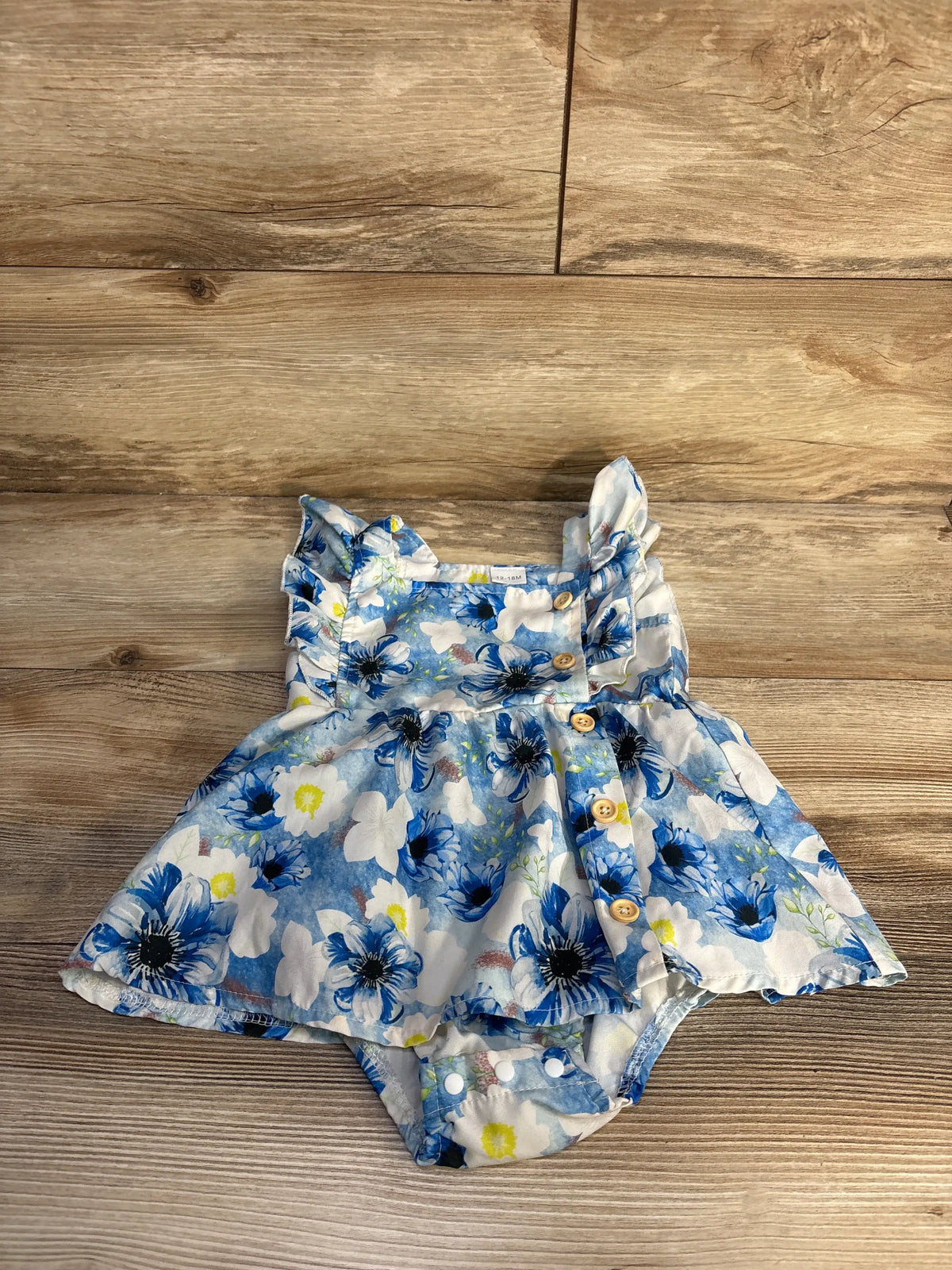 Top view of EYIIYE blue fly sleeve bodysuit dress showcasing floral print and button closure on wood flooring