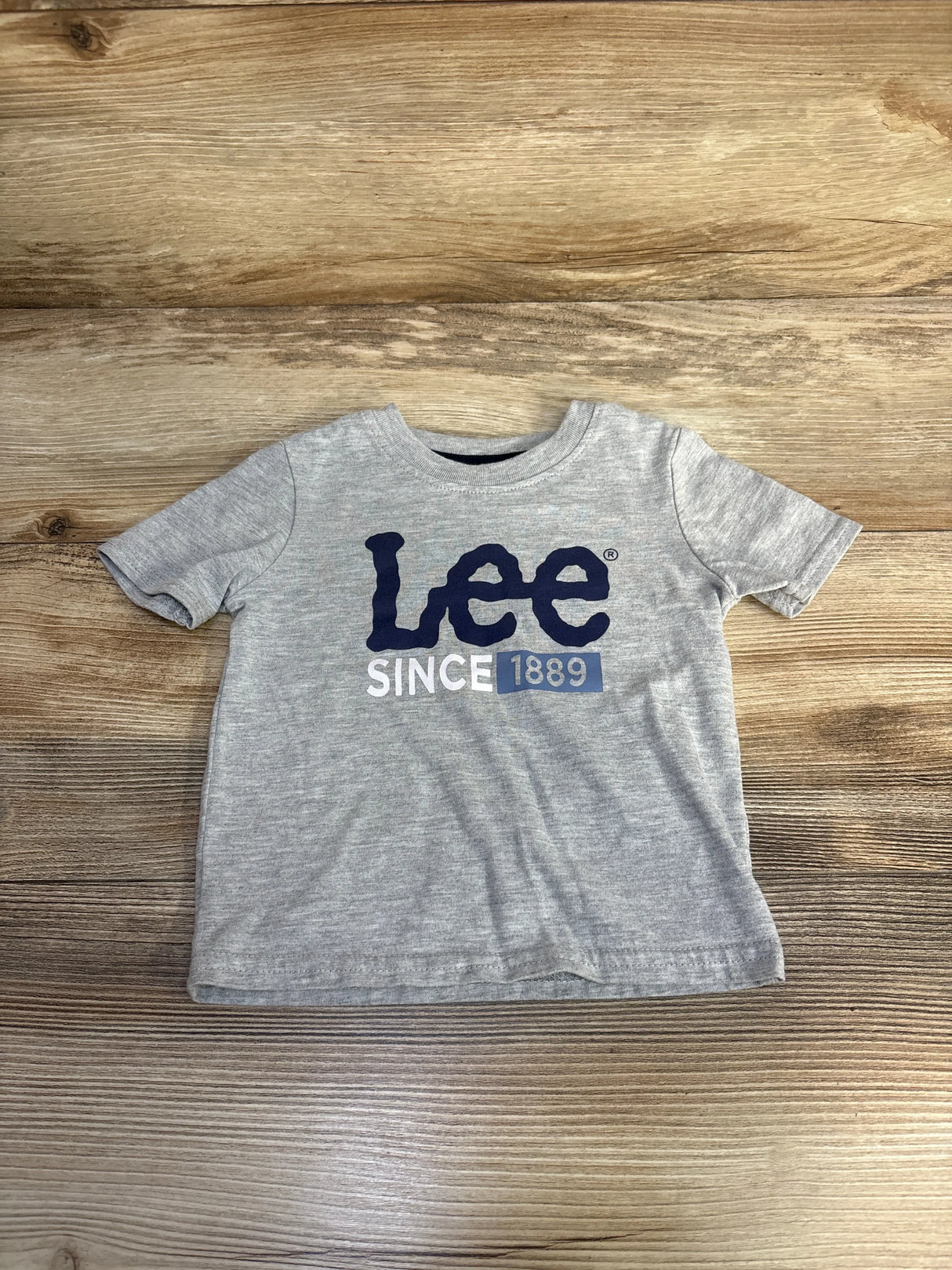 Gray Lee branded toddler t-shirt with navy logo and 'Since 1889' text on wooden surface