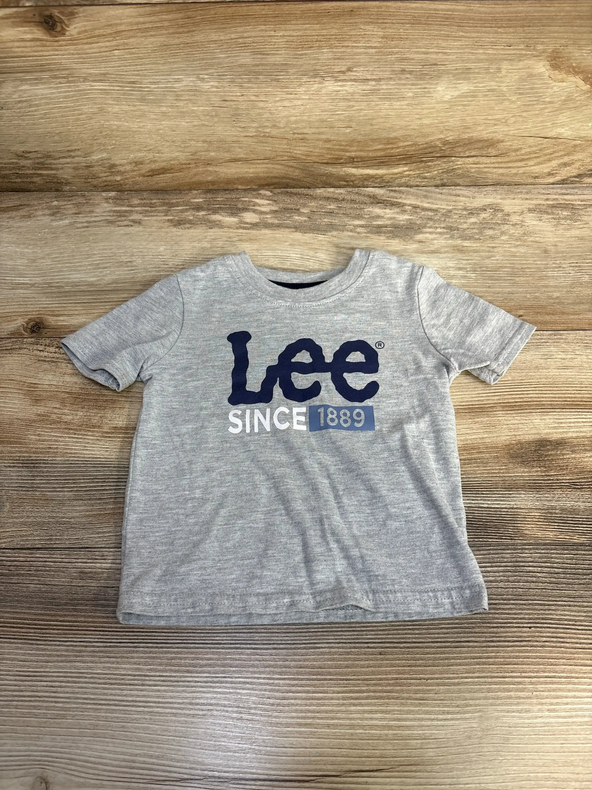 Gray Lee branded toddler t-shirt with navy logo and 'Since 1889' text on wooden surface