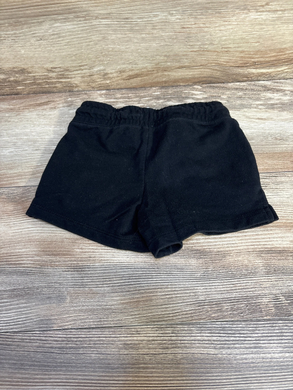 Front view of black Cat & Jack knit toddler shorts size 5T showing elastic waistband and short inseam on wood background