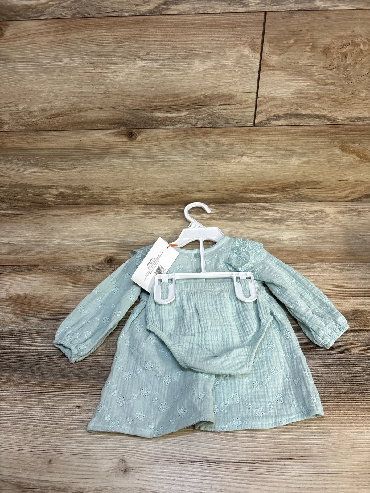 Front view of mint eyelet lace cotton dress set 3-6m with long sleeves and matching bloomers on wood background