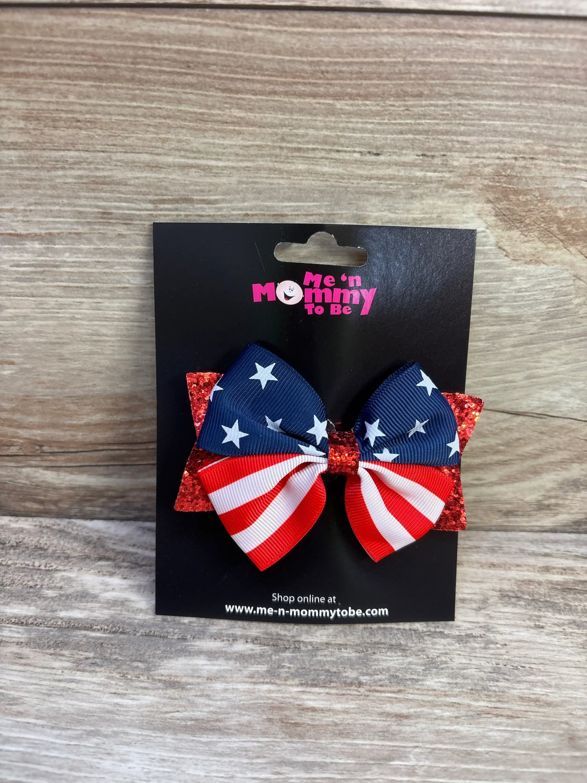 Front view of American-flag glitter hair bow with blue stars, red-and-white stripes and red glitter backing on black display card