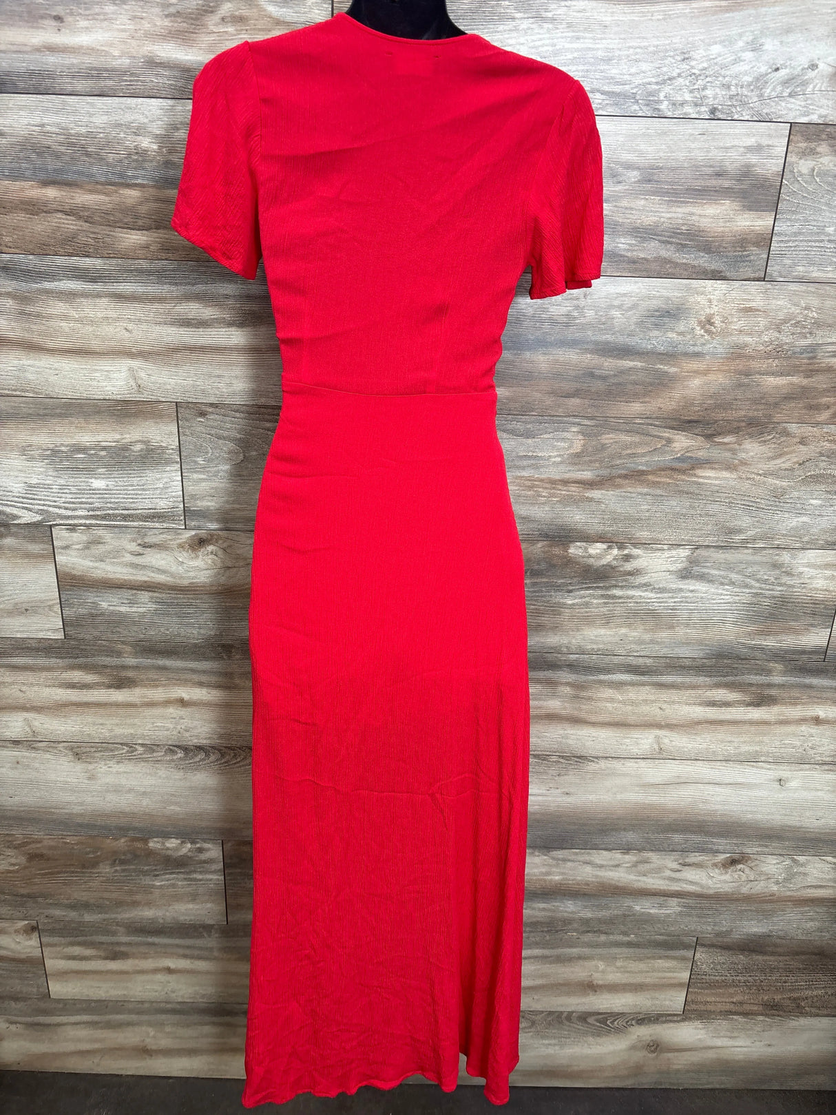 Back view of Lulus Much Obliged wrap maxi dress in red (maternity XS) showing short sleeves and fitted waist on mannequin against wood background