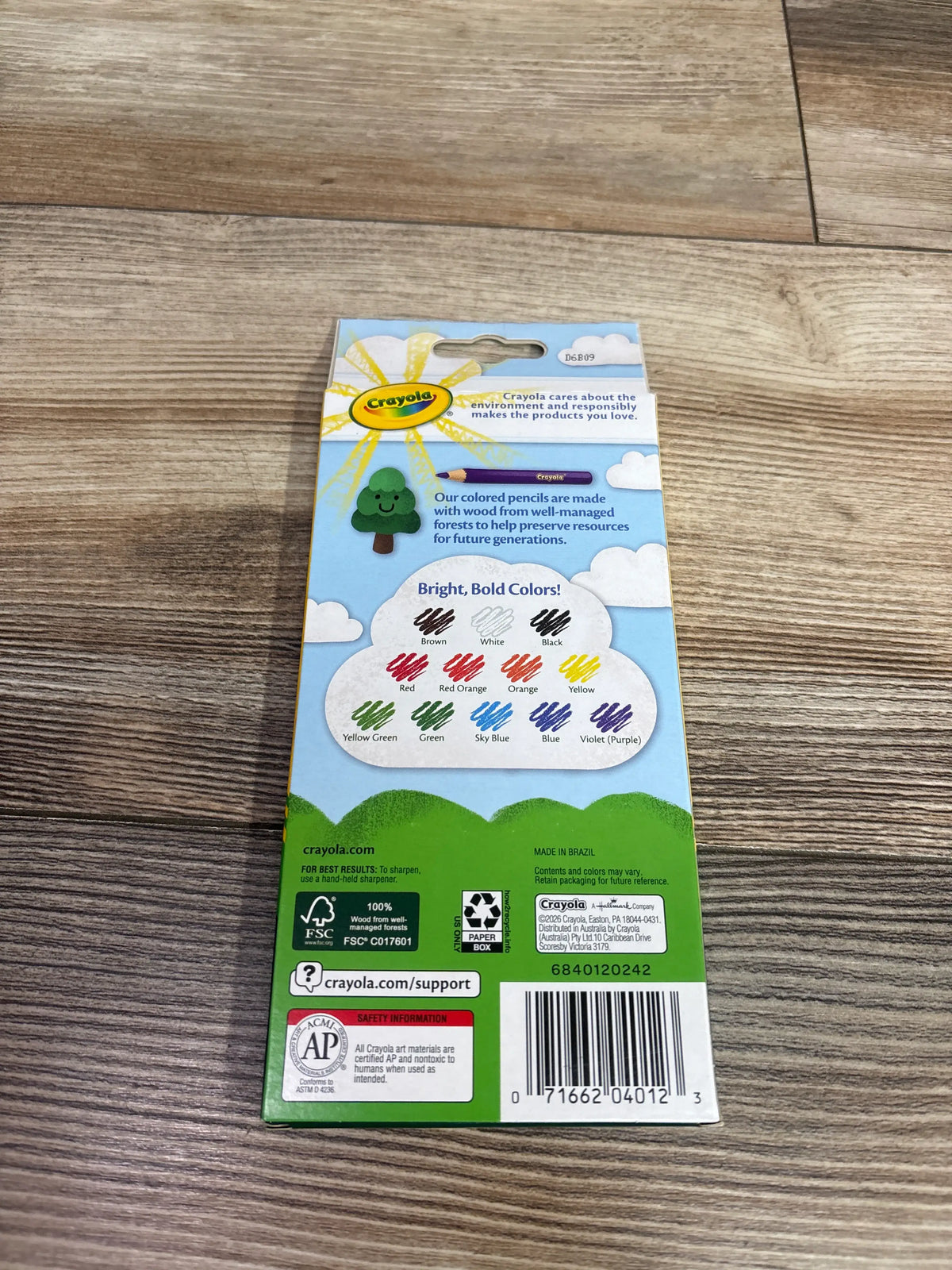 Back view of NEW Crayola 12ct Colored Pencils package showcasing bright, bold color chart with wood floor background
