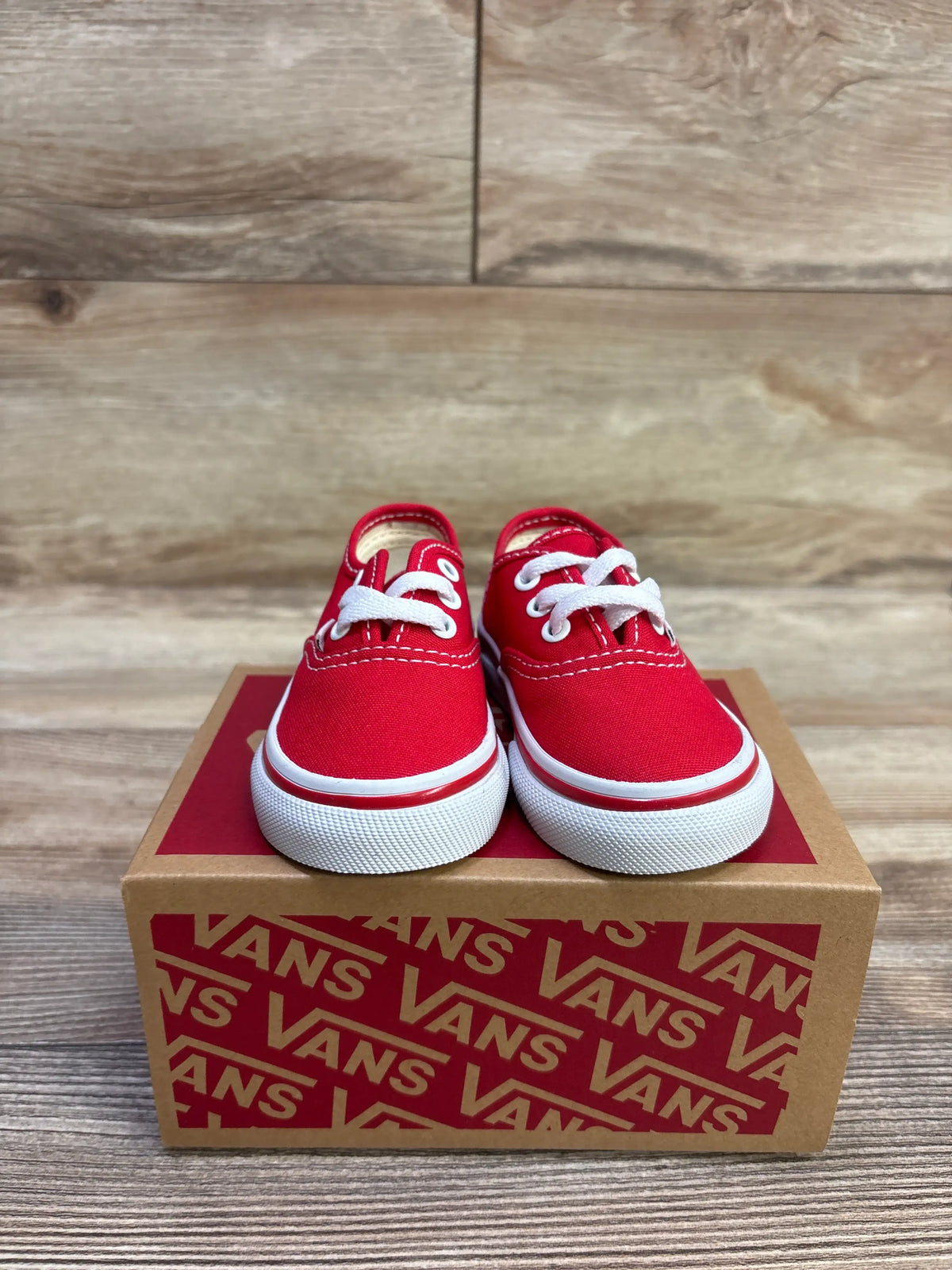 Front view of new red Vans Authentic lace-up sneakers, size 3.5C, with white laces and soles on a Vans shoebox