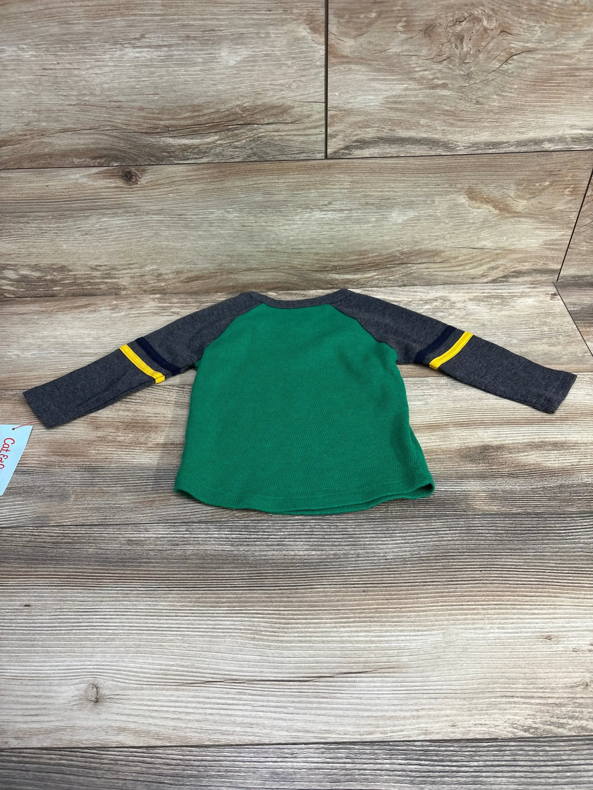 Back view of Cat and Jack toddler shirt (12M) showing green body gray sleeves with yellow and navy stripes on floor