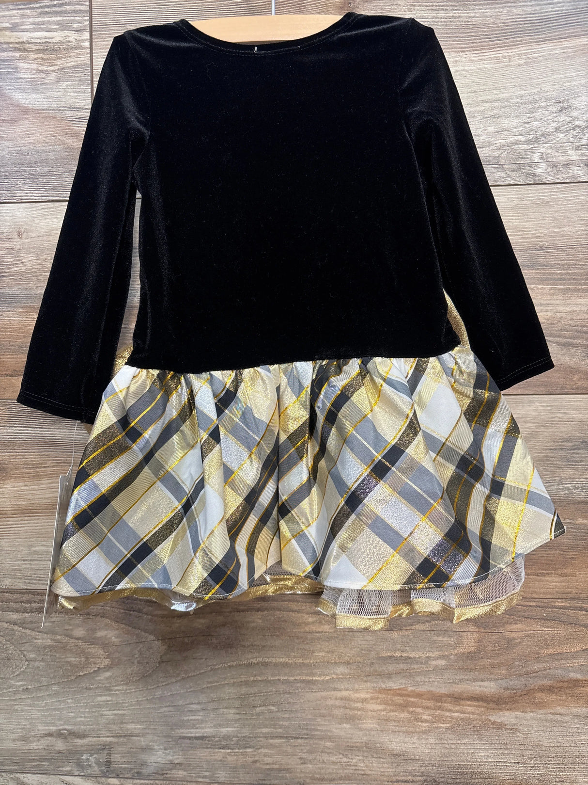 Black velvet long sleeve top with gold and gray plaid skirt dress on wooden floor