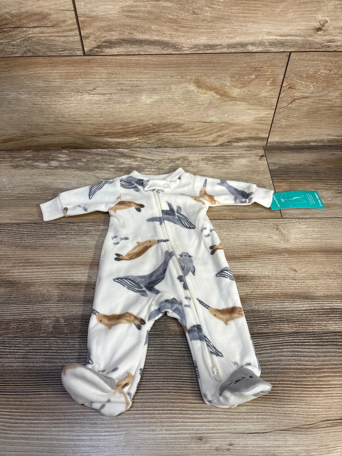 Front view of Child Of Mine white blanket sleeper showcasing animal print and full length zipper on a wood floor