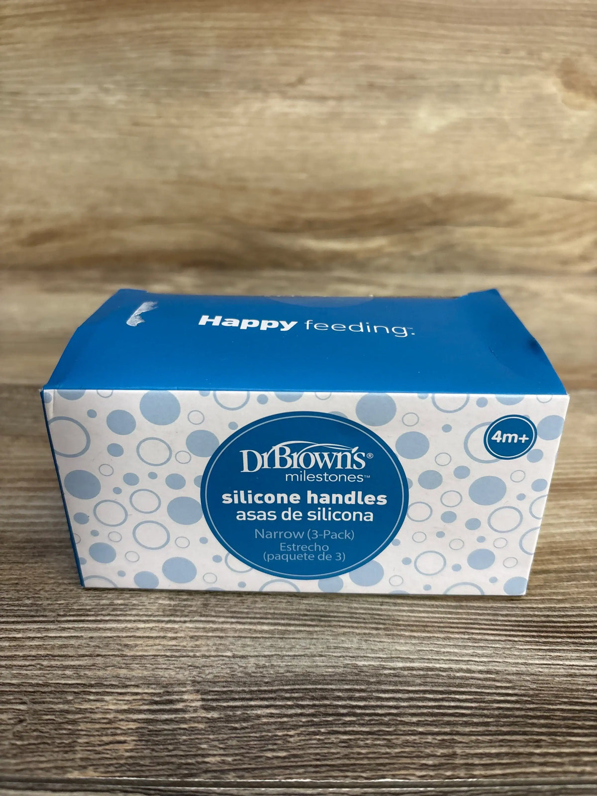 Dr. Brown's silicone handles box for baby bottles, 3-pack, 4 months and up, on wood surface