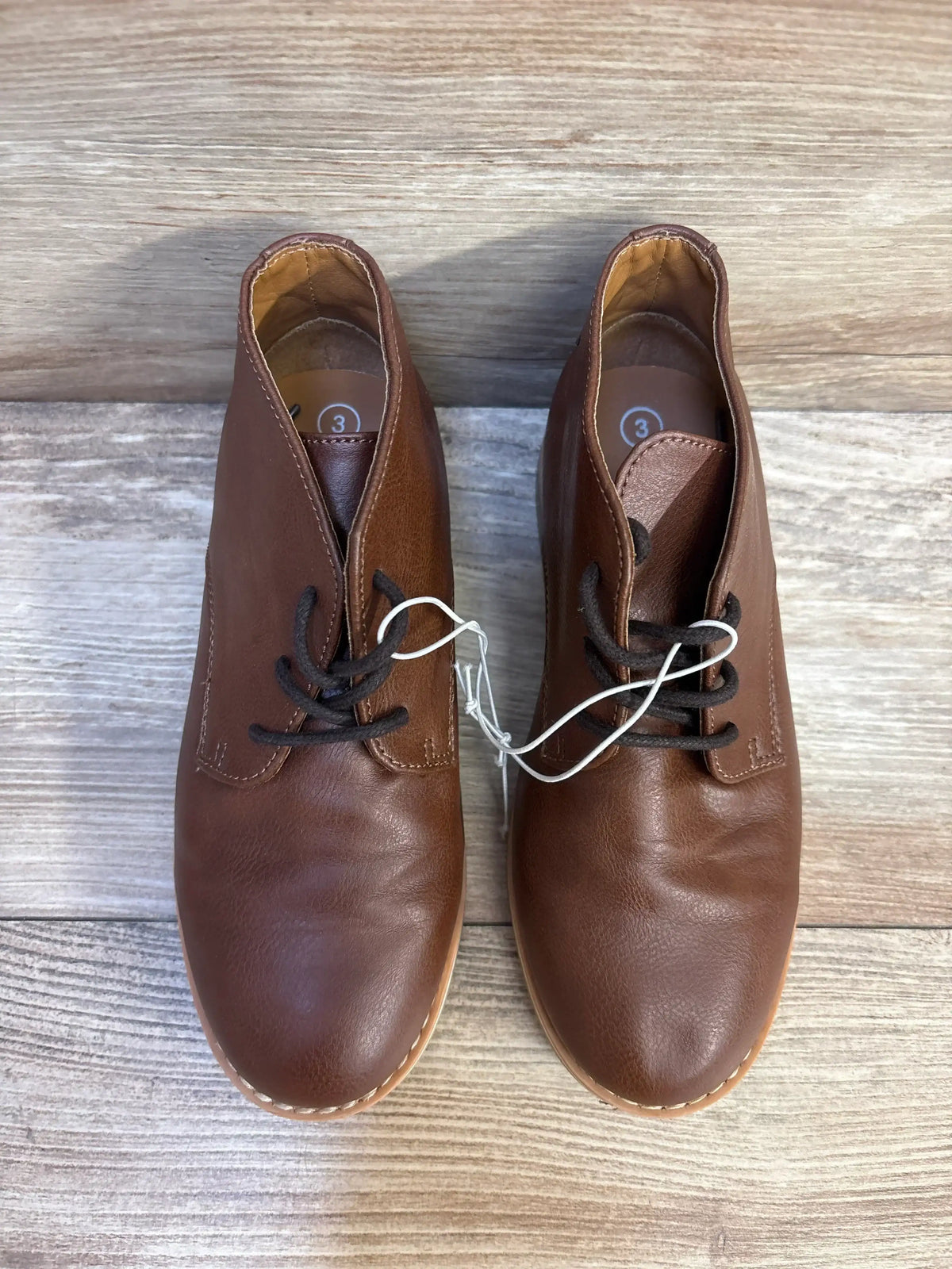 Top view of Cat & Jack Filip boots in brown showcasing lace-up closure on a wood floor