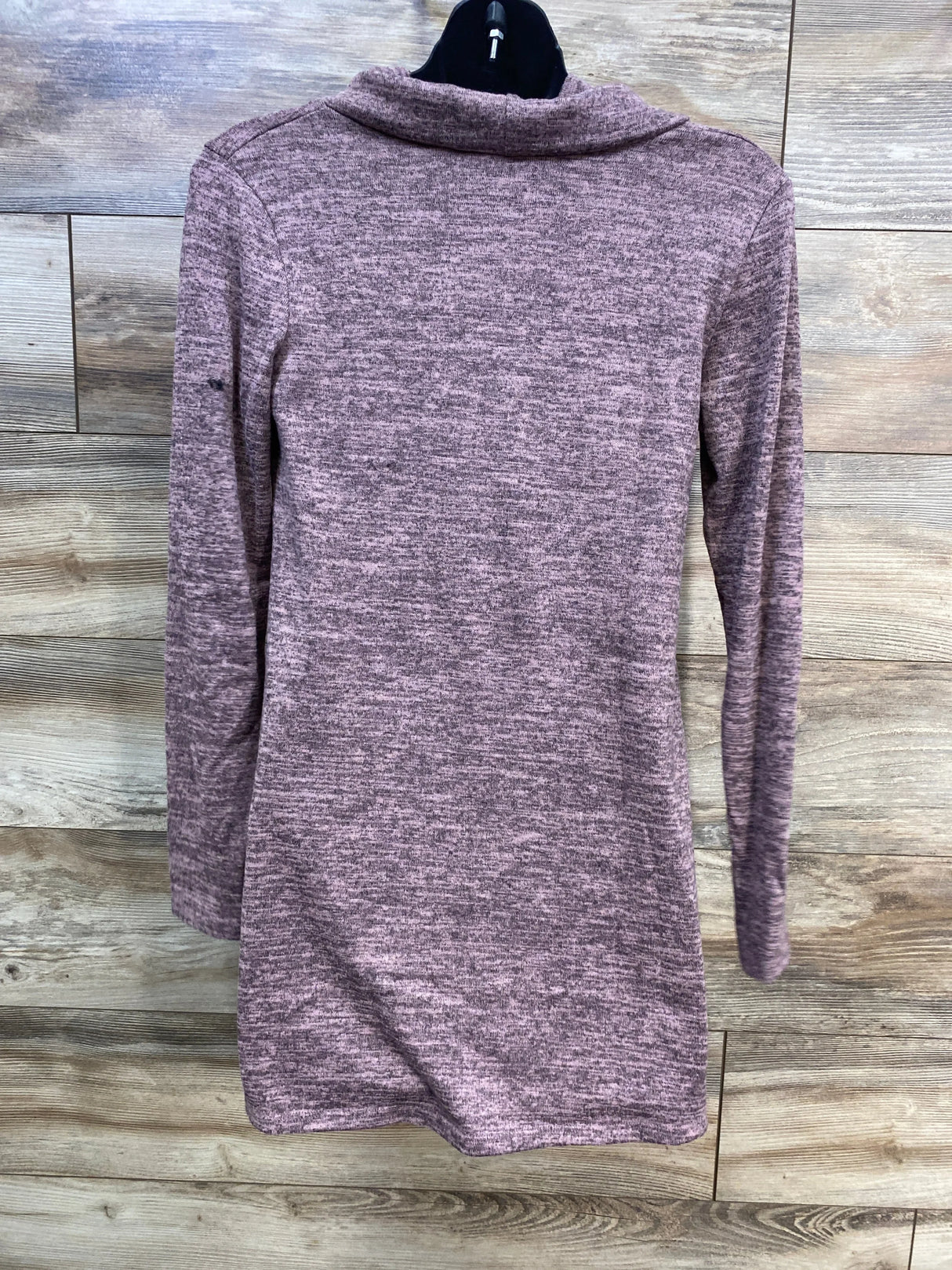 Back view of Hello MIZ shawl-collar maternity tunic sweater in mauve showing sleeves on black hanger against wood background