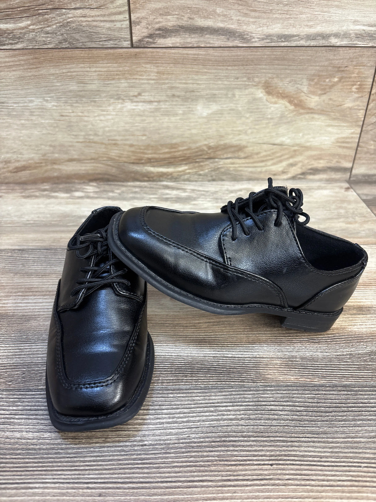Black leather boys dress shoes with laces on wood floor, gently used kids footwear
