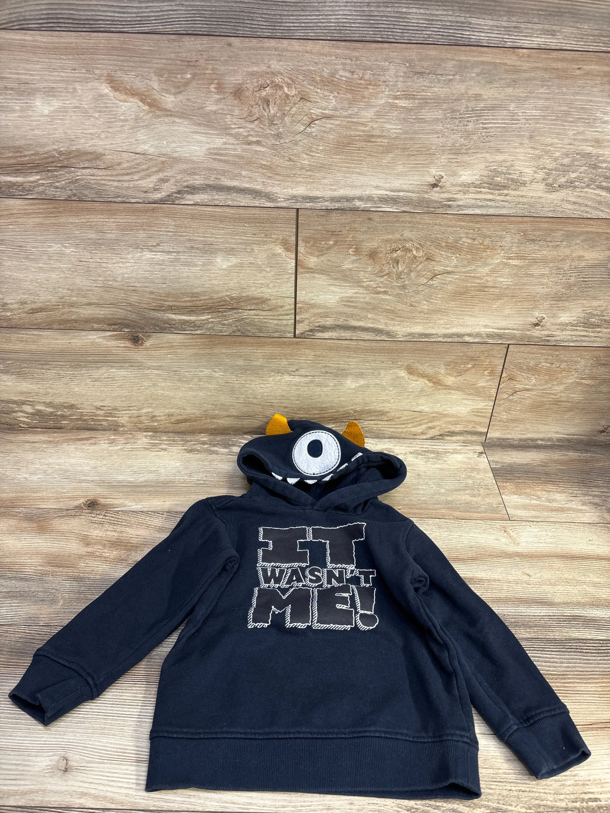 Front view of navy Kids Headquarters hoodie size 4T showing It Wasn't Me graphic and monster hood with single eye and horns