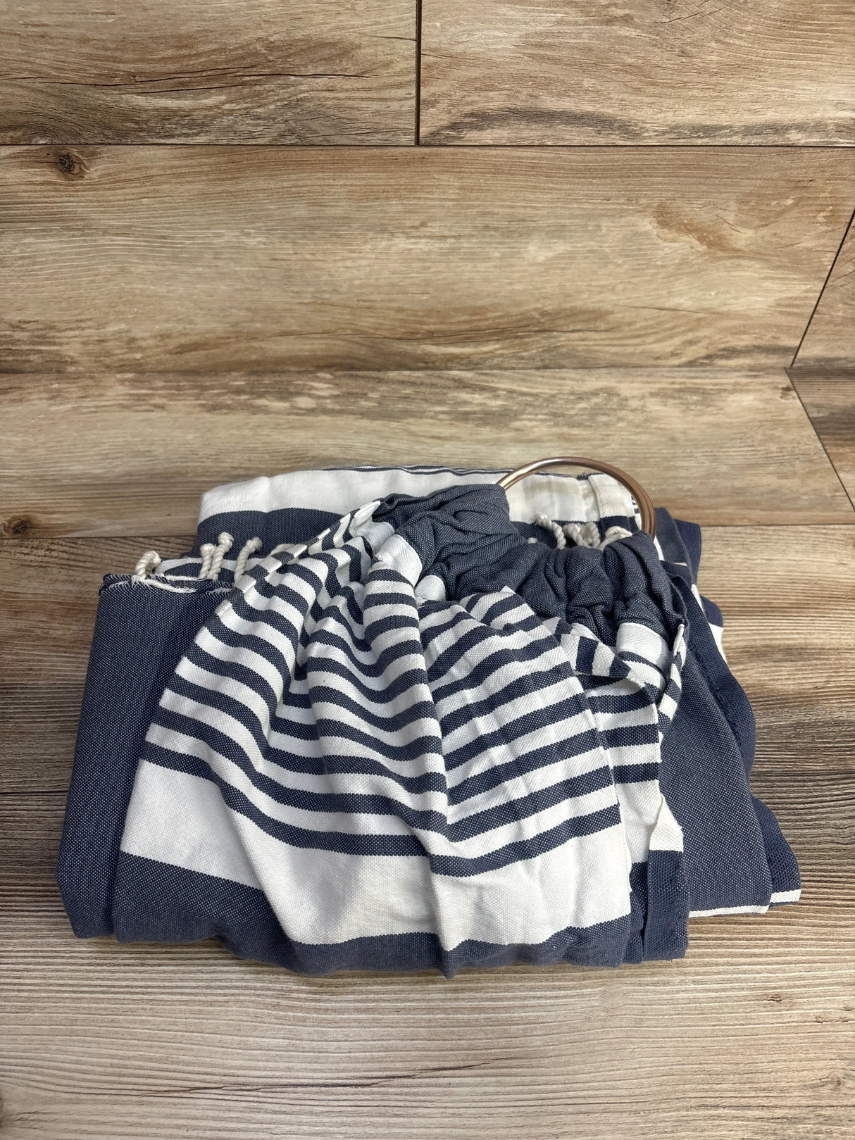 Navy and white striped baby ring sling carrier folded on wood