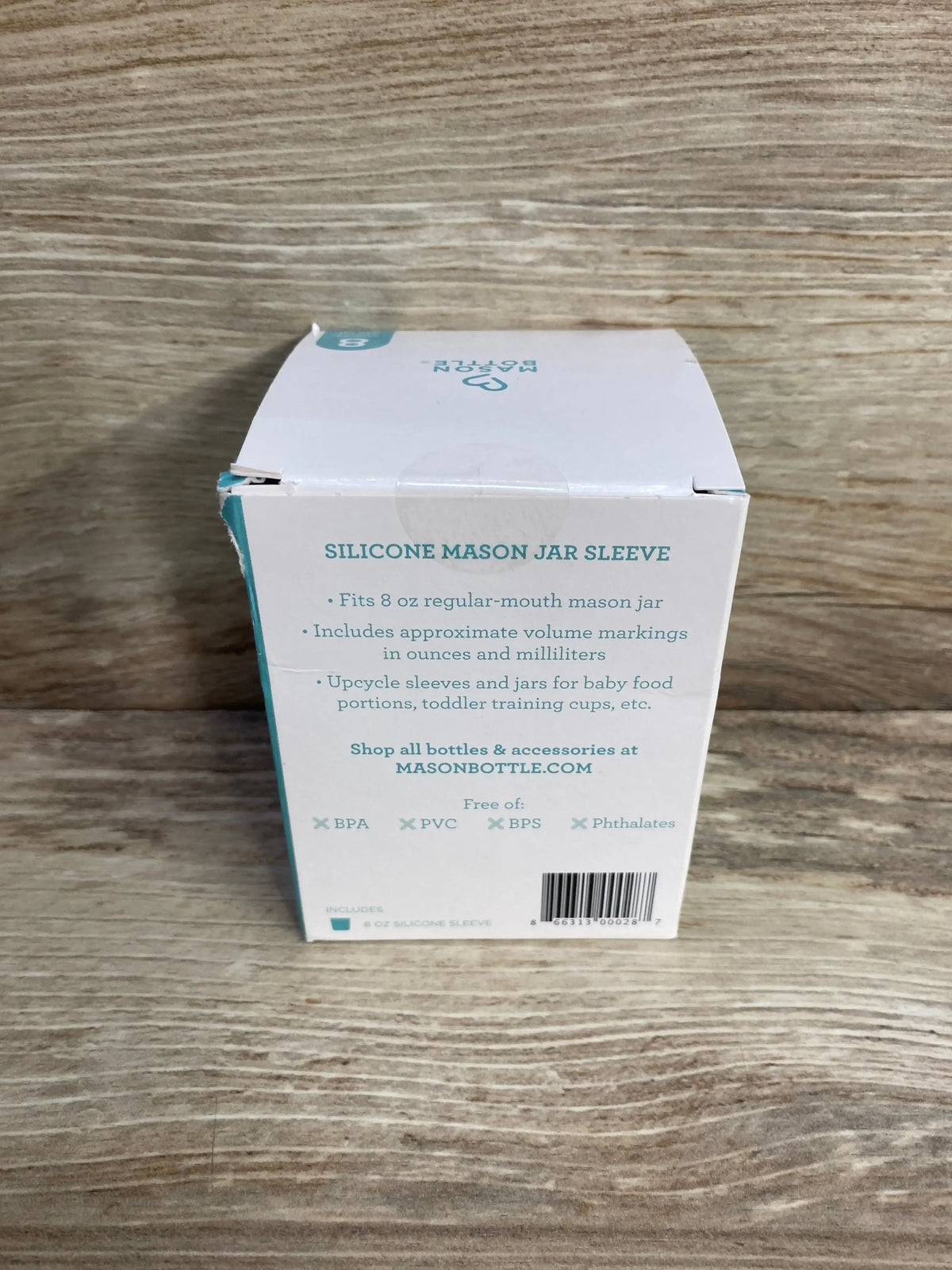 Front view of silicone mason jar sleeve box showcasing 8 oz fit and approximate volume markings with wood tabletop background