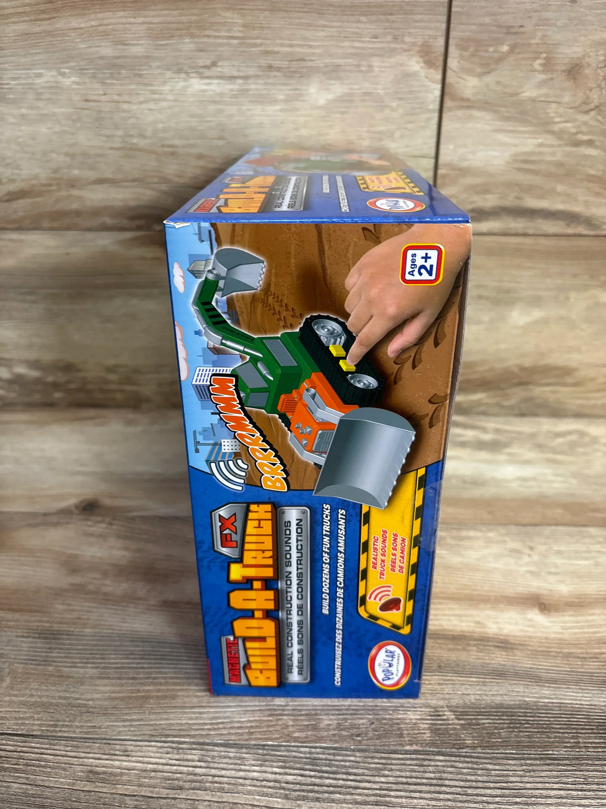 Build-A-Truck toy vehicle box for ages 2+, real construction sounds, on wood surface