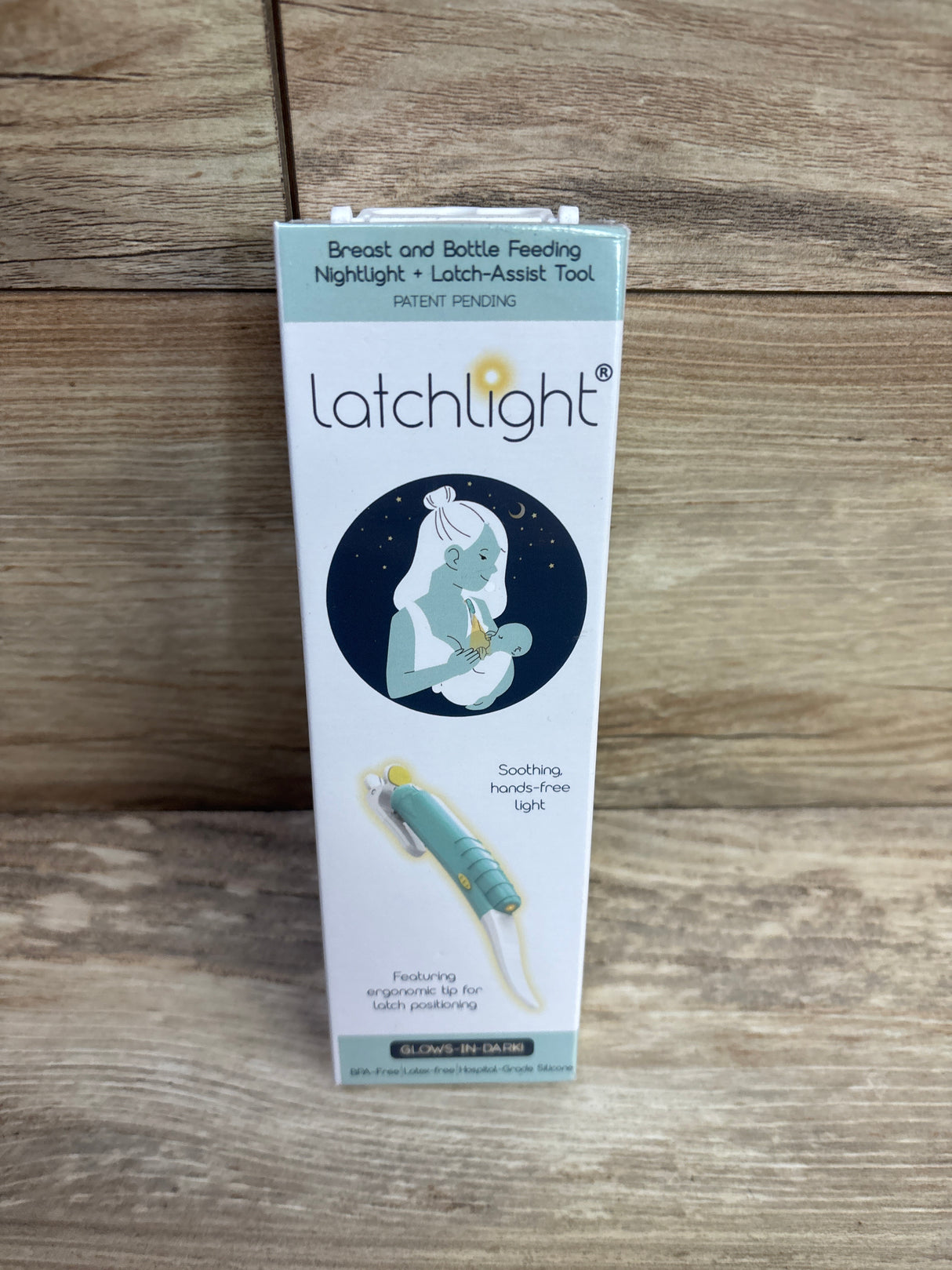 Latchlight breast and bottle feeding nightlight with latch-assist tool packaging on wood background
