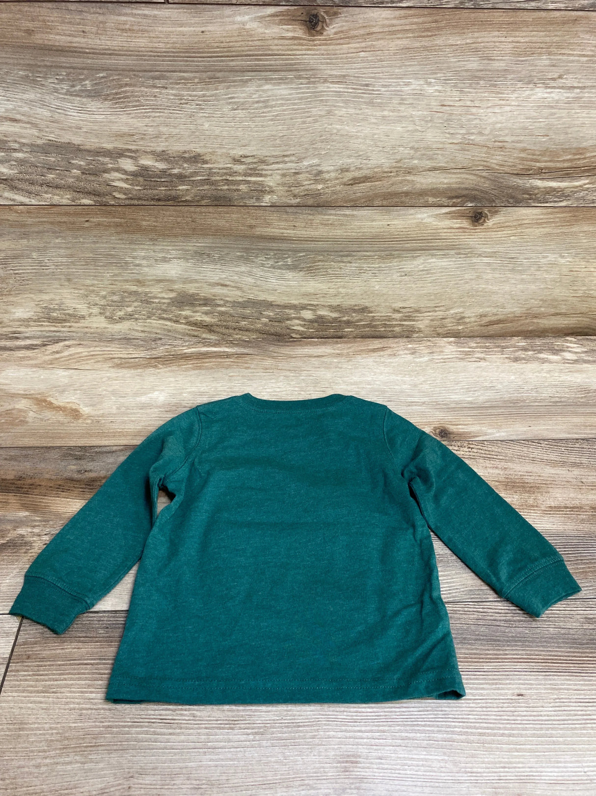 Teal kids long sleeve shirt laid flat on wood floor, perfect for toddler or baby clothing resale