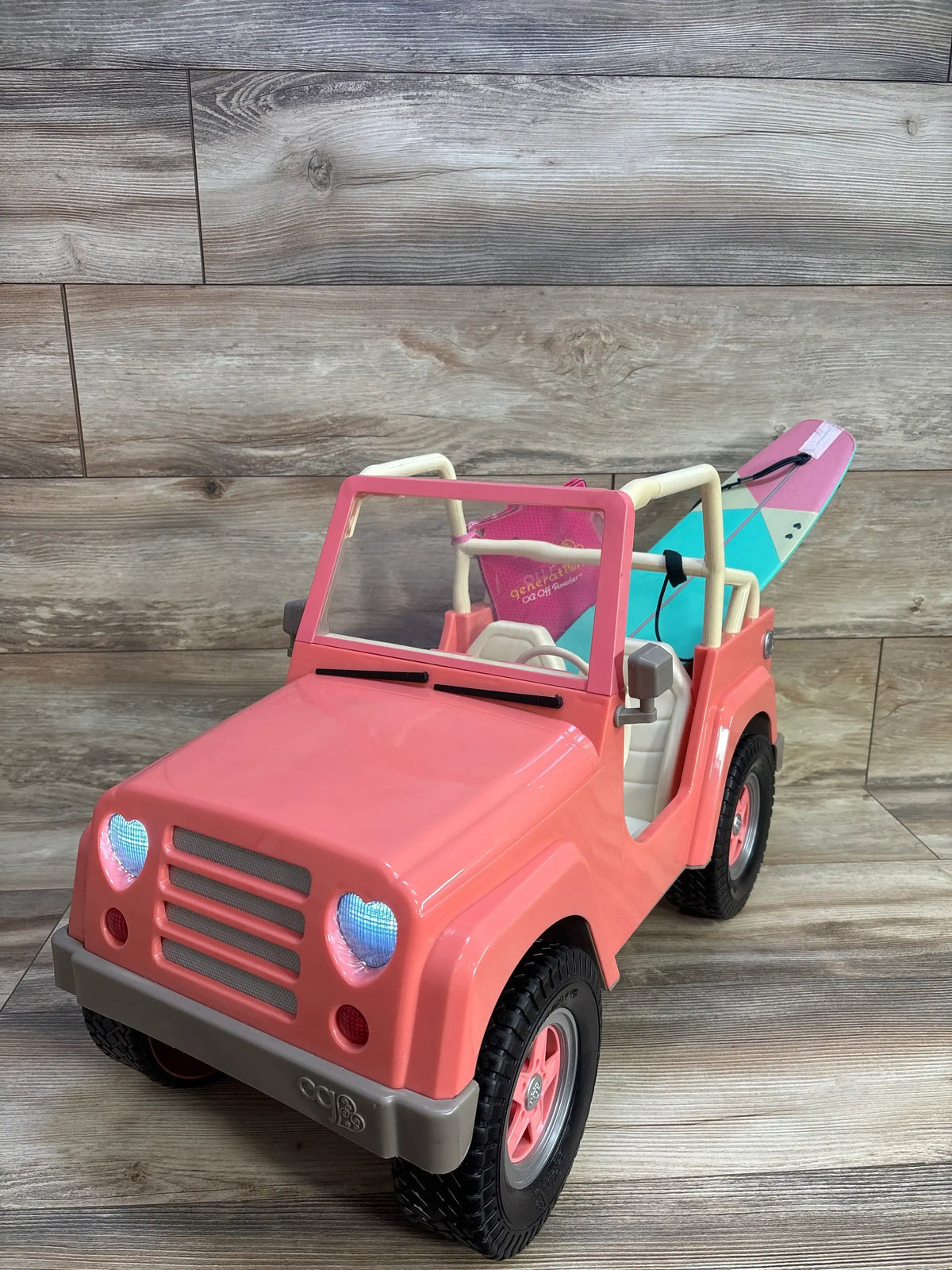 Our Generation Off-Roader 4x4 doll vehicle in pink with a surfboard on the back
