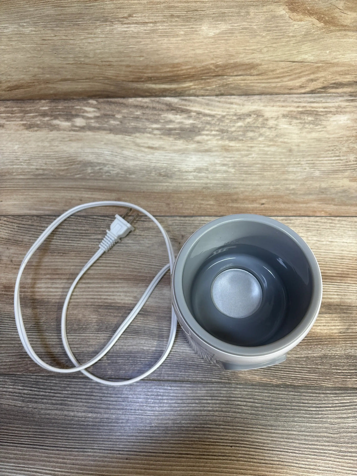 Top view of Grownsy Baby Bottle Warmer, White showcasing open warming basin and attached power cord on a wood-grain surface