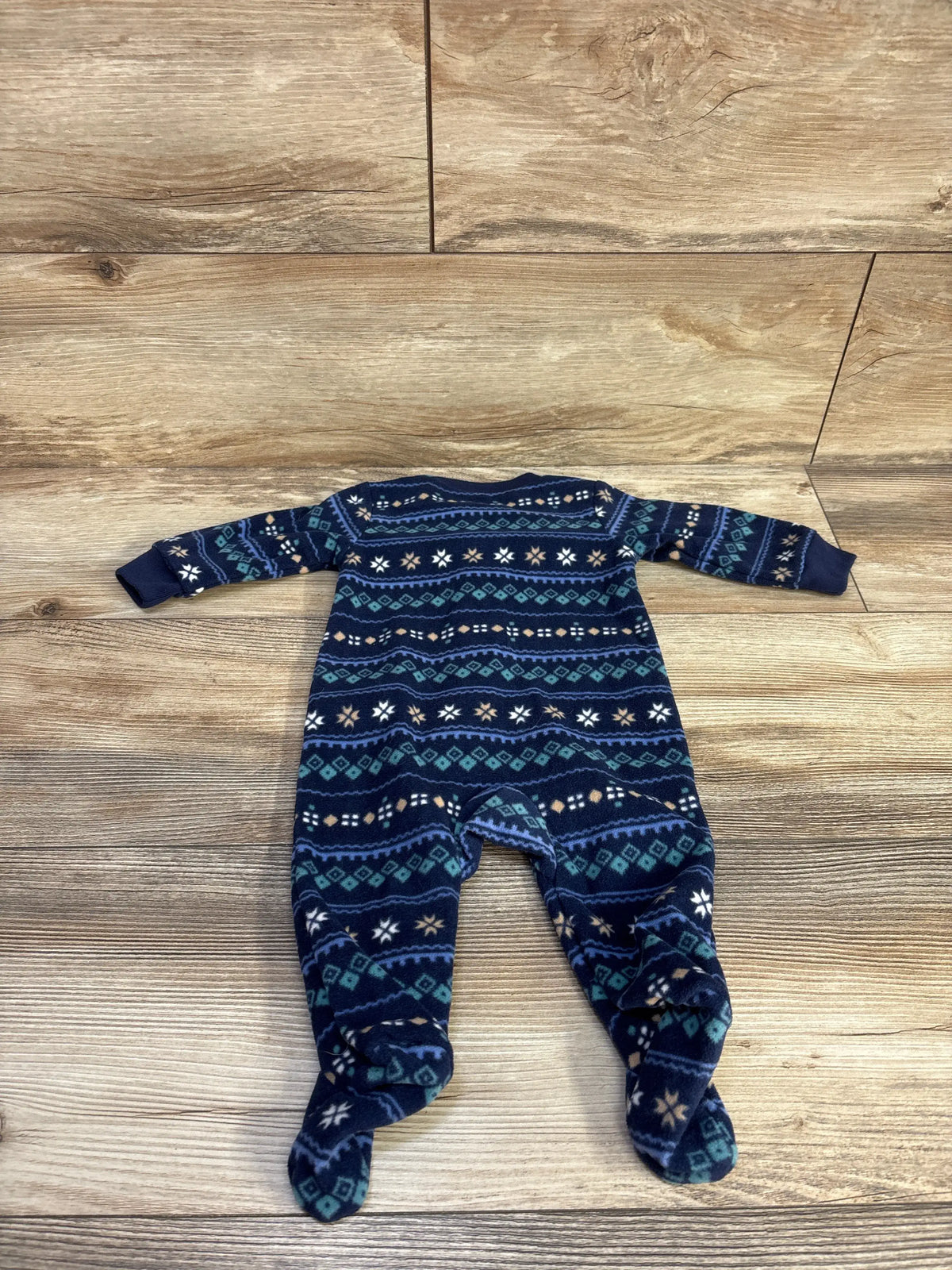 Top-down view of Carter’s blue blanket sleeper in size 3 months showcasing patterned fabric and footed legs on a wood floor