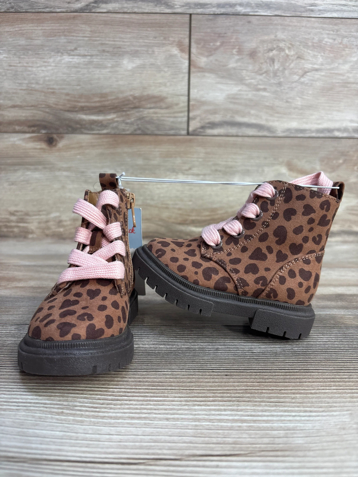 Kids brown leopard print boots with pink laces on wood background