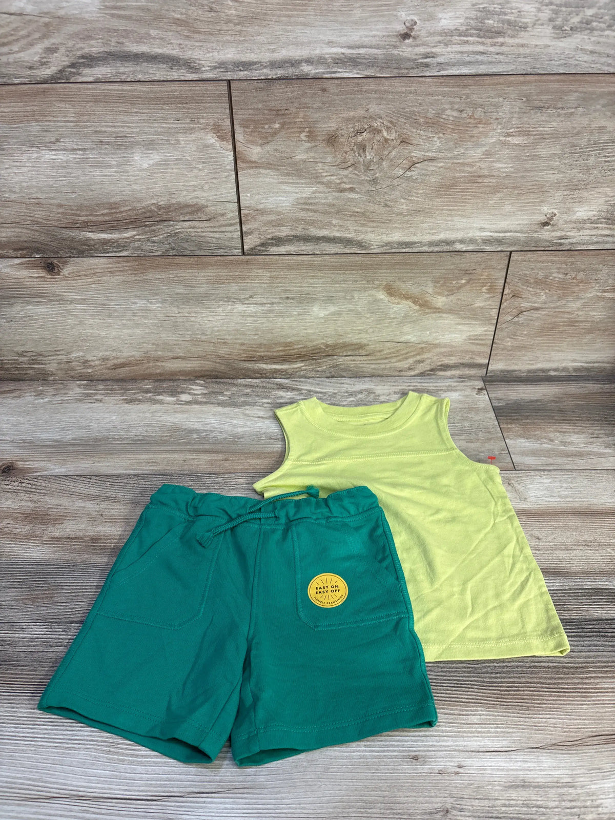 Front view of Cat and Jack 2pc tank top and shorts set showcasing lime green tank and drawstring shorts on wood planks