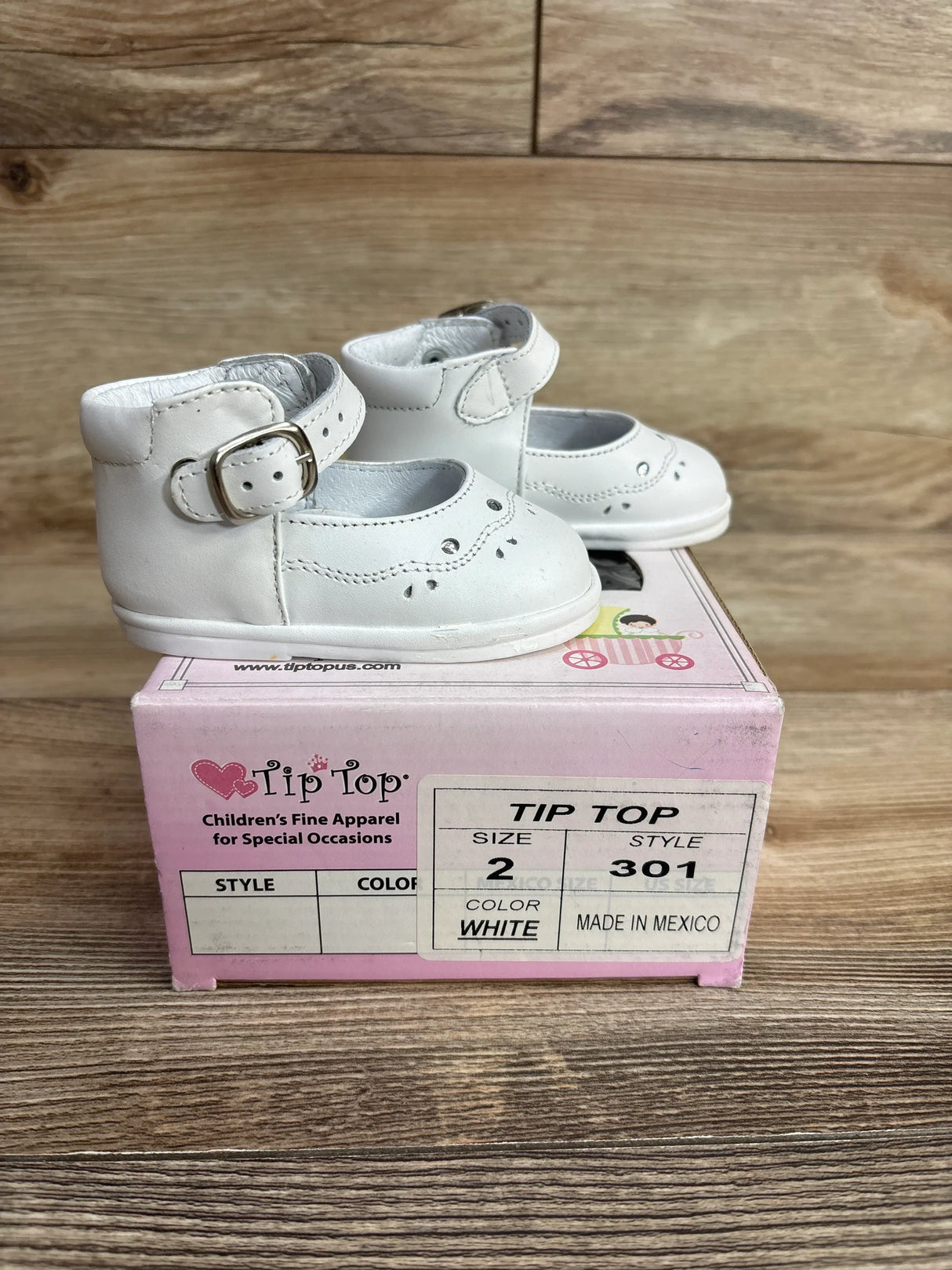White baby shoes size 2 with buckle detail on pink Tip Top children's shoe box