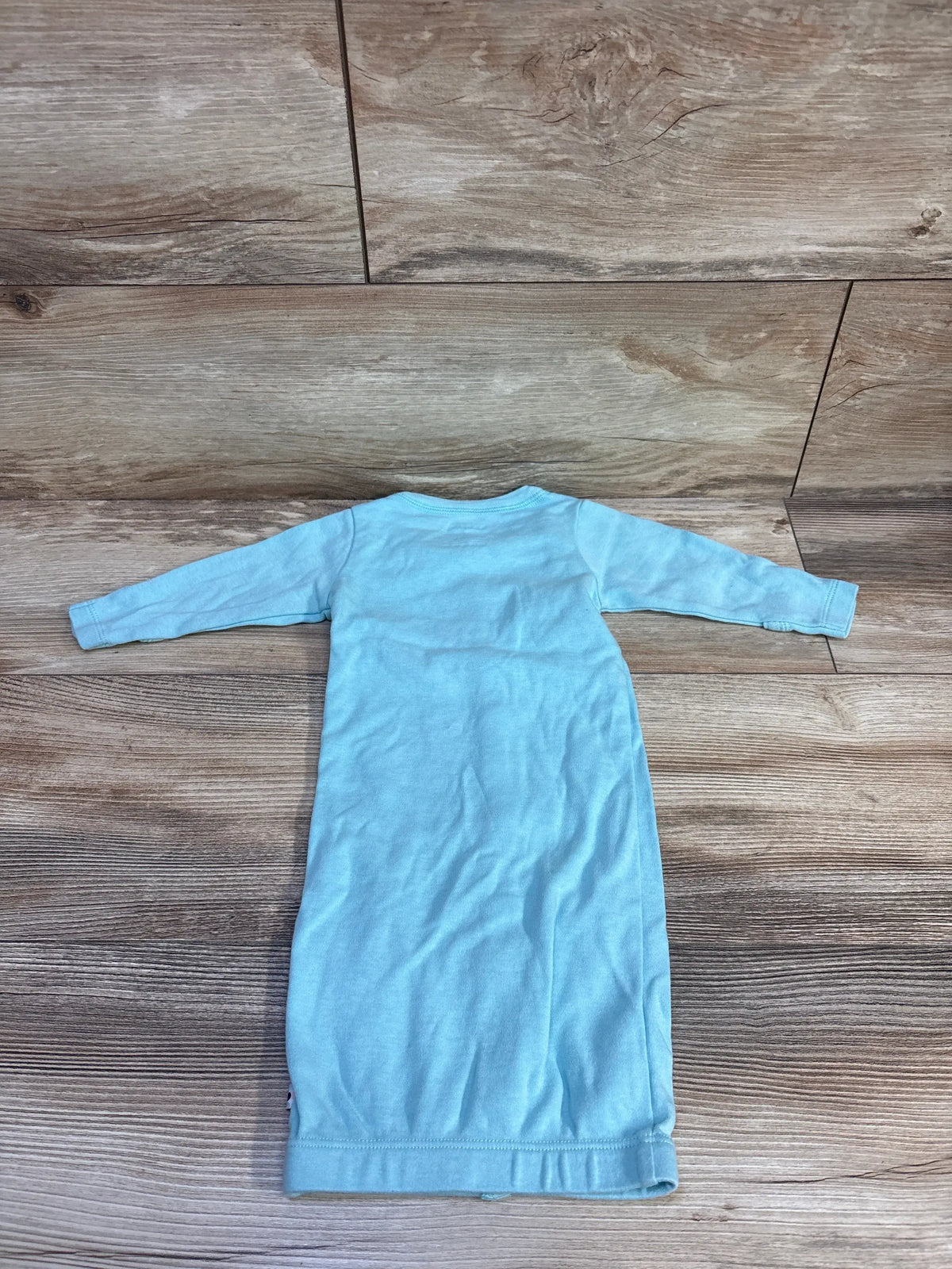 Back view of Babysoy blue long sleeve snap sleep gown showcasing full length body and elastic hem on wood background
