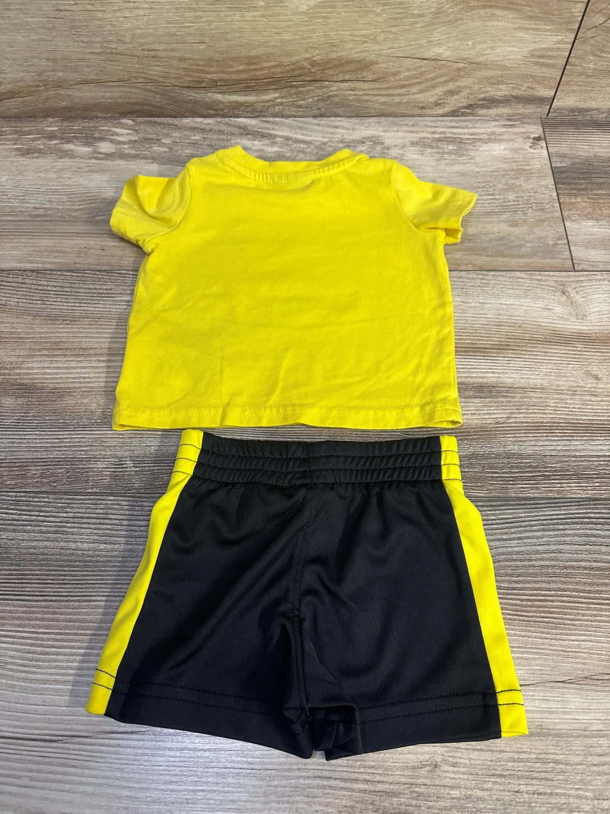 Puma 2-piece infant set featuring a bright yellow t-shirt and black shorts with yellow stripes.