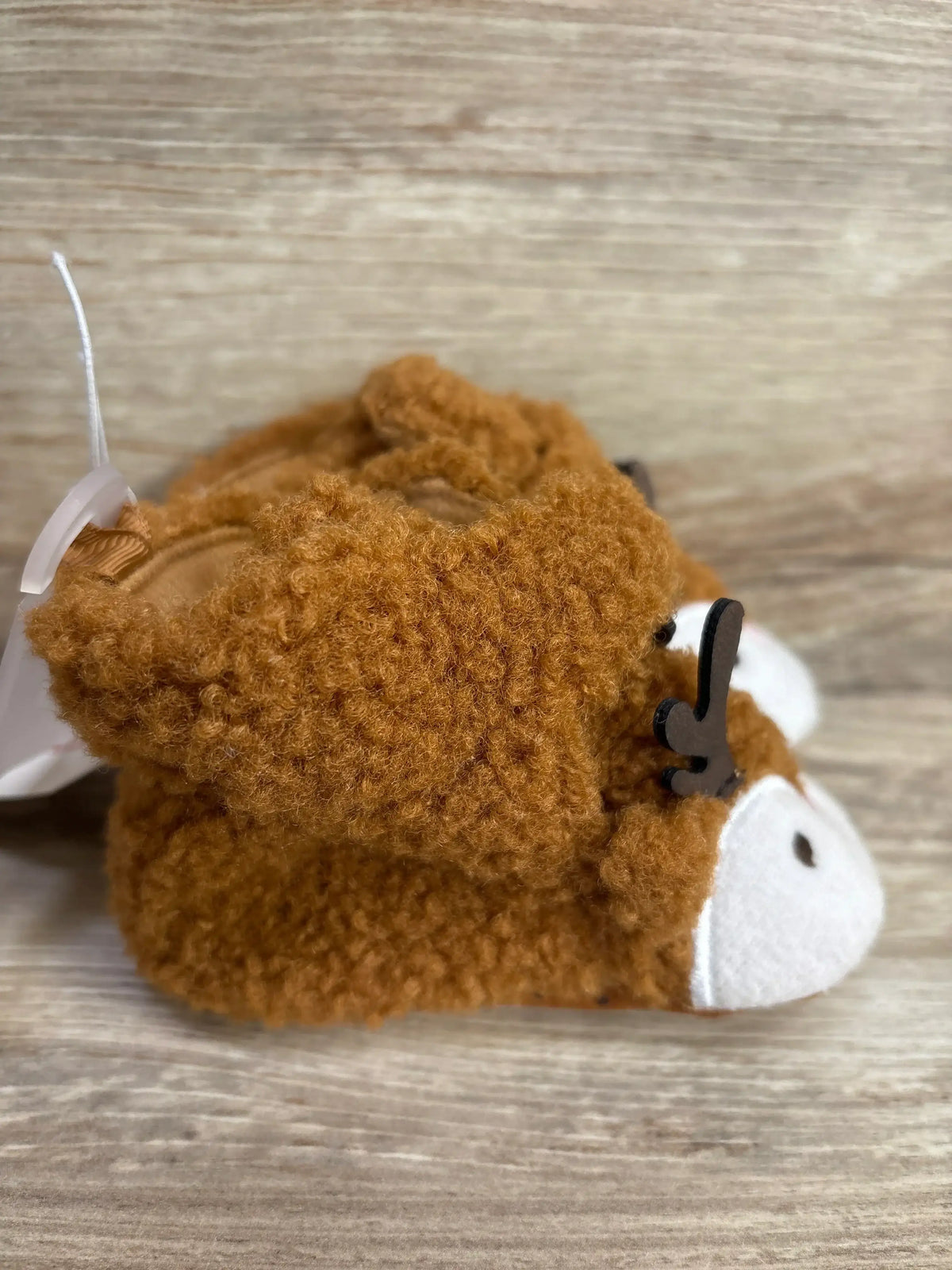Soft brown reindeer baby booties with white snout and antlers, perfect for newborns and infants.
