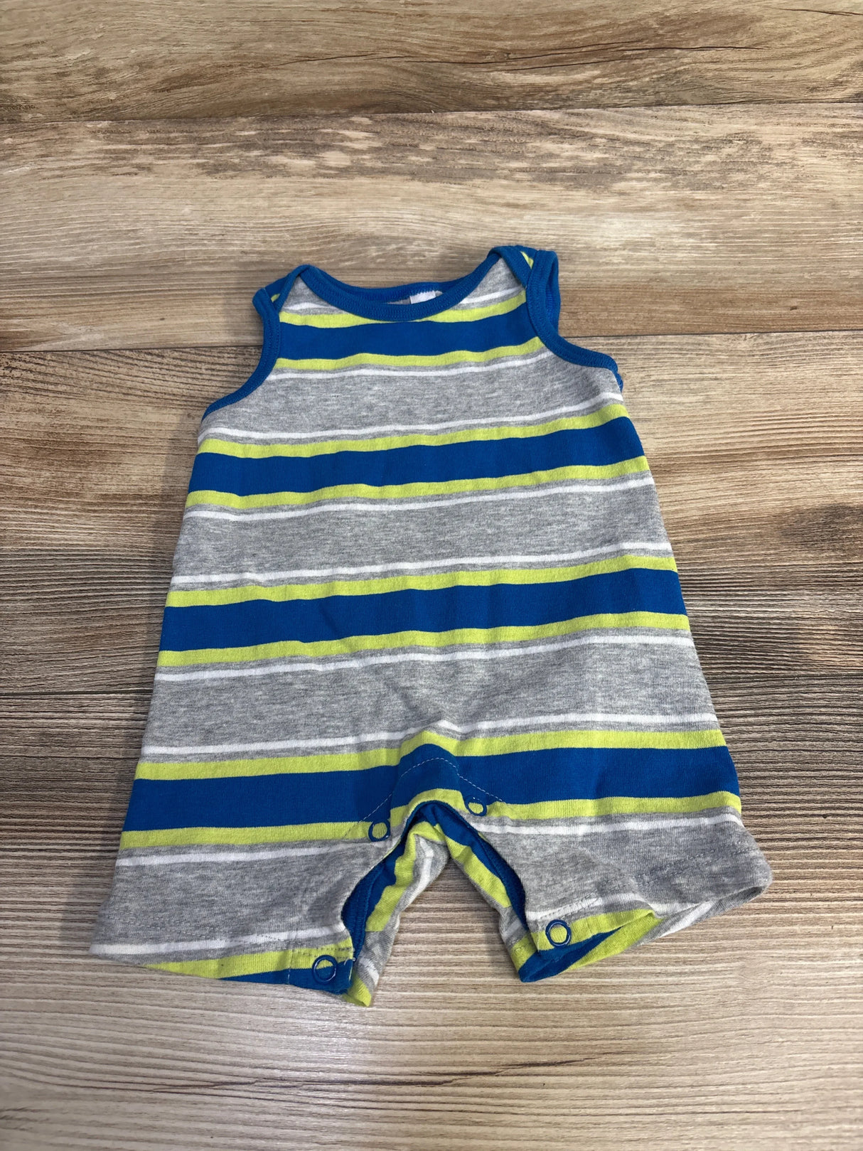Striped baby romper with blue, gray, and green colors on wooden background