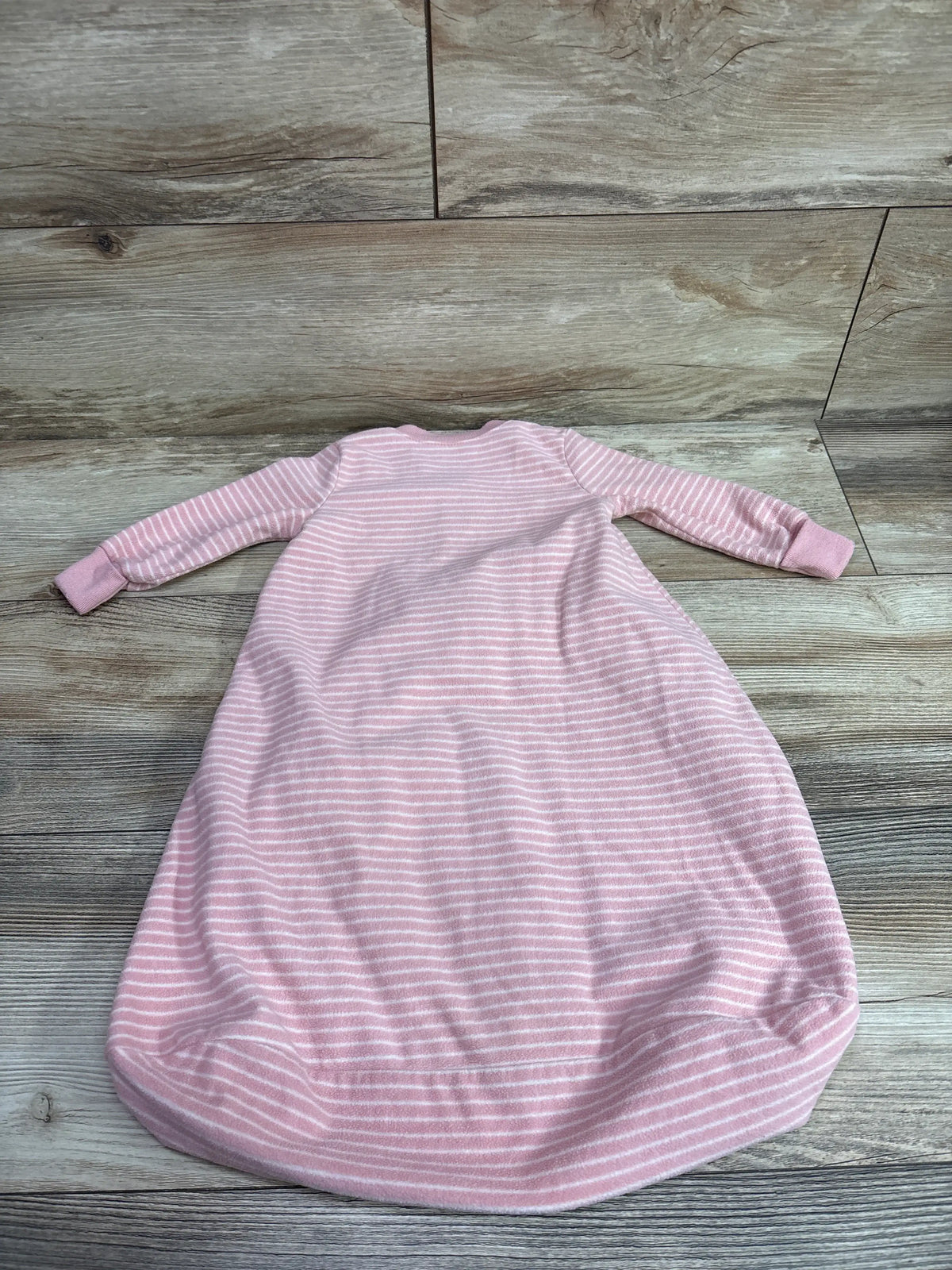 Carter's pink and white striped baby blanket sleep sack, size 0-3m, on a wooden background