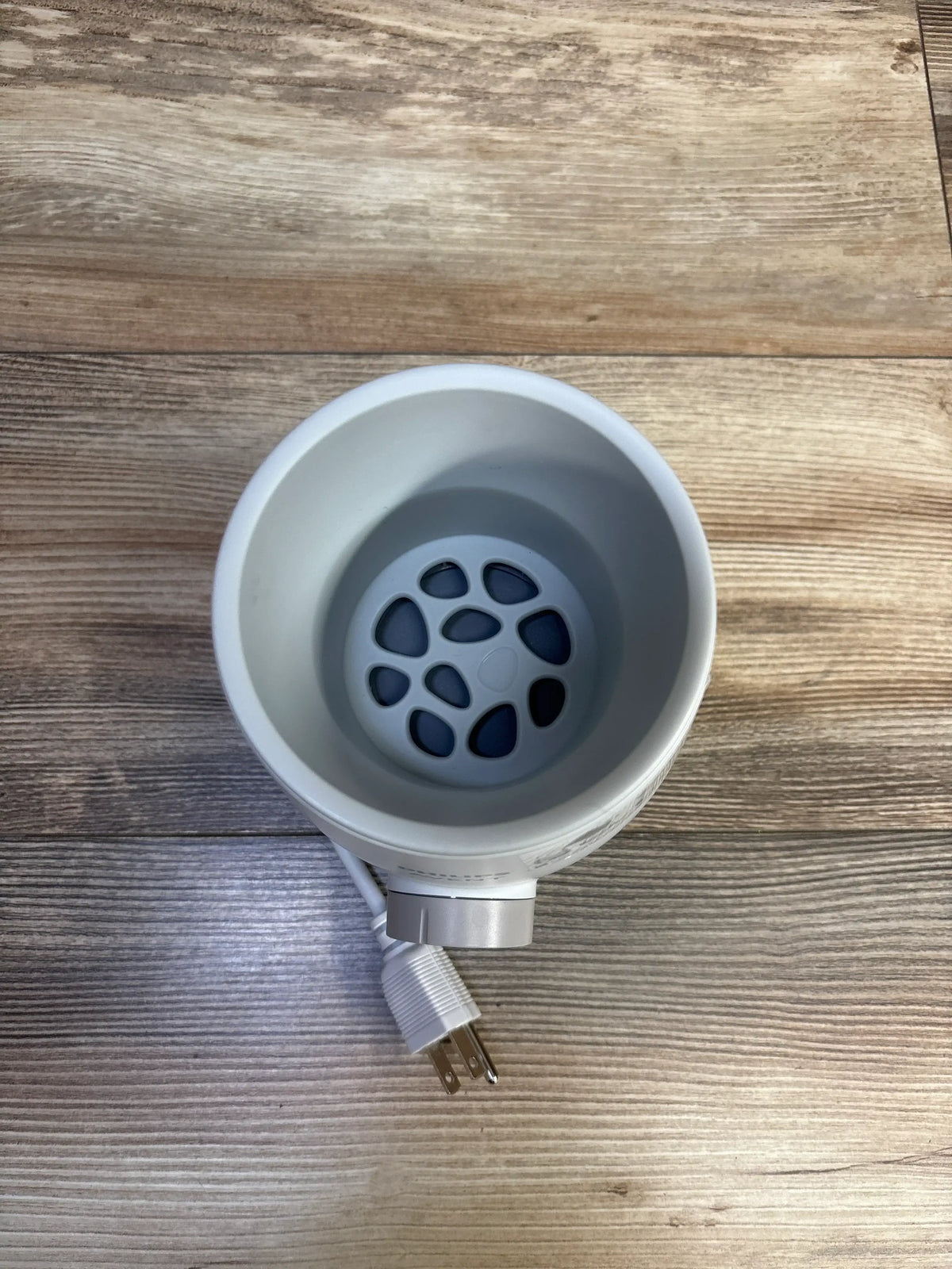 Top view of a white Me n Mommy To Be baby bottle warmer on a wooden surface.
