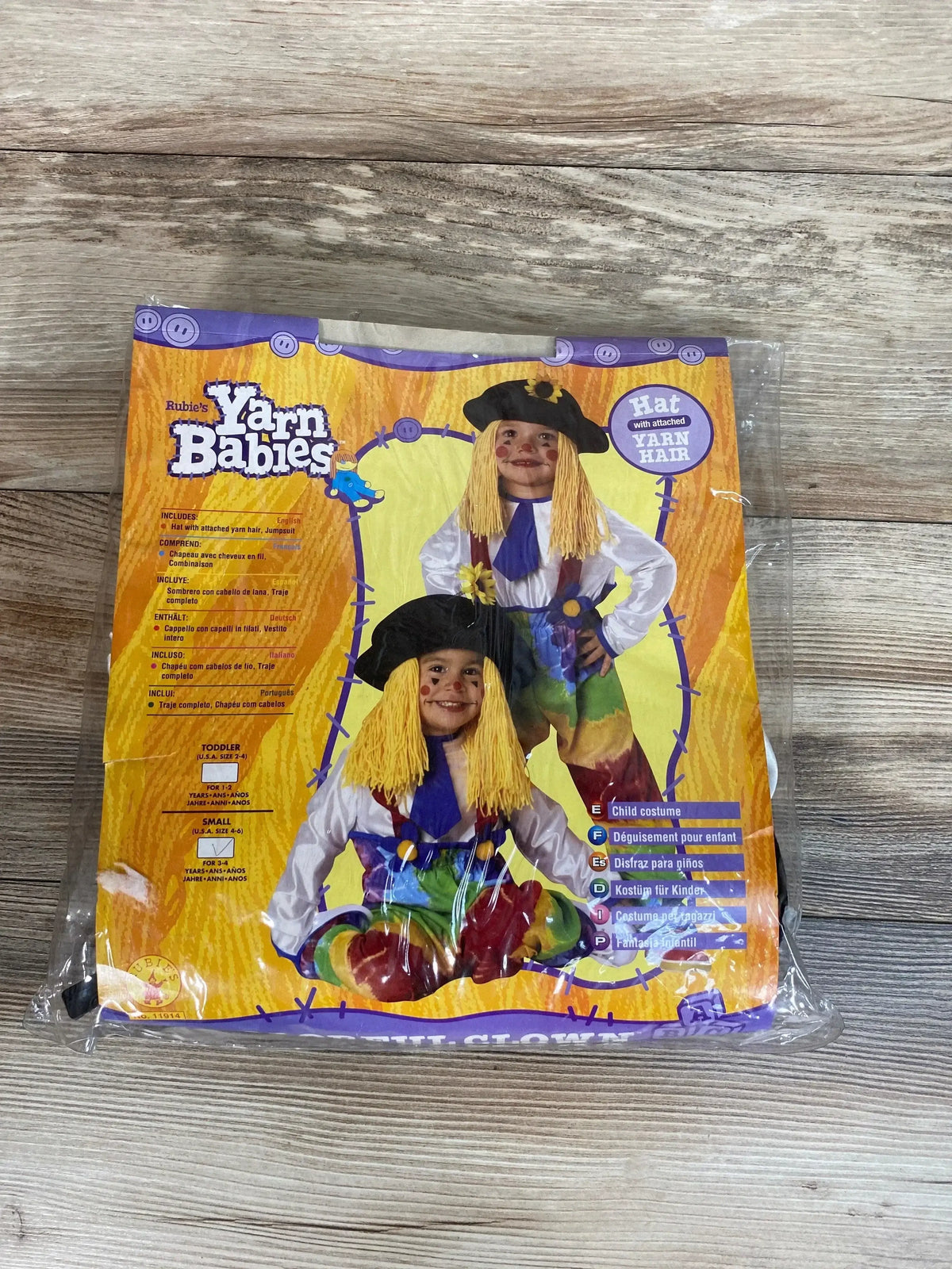 Front view of Rubie’s Yarn Babies colorful clown costume in a sealed package, showing a hat with yarn hair and jumpsuit