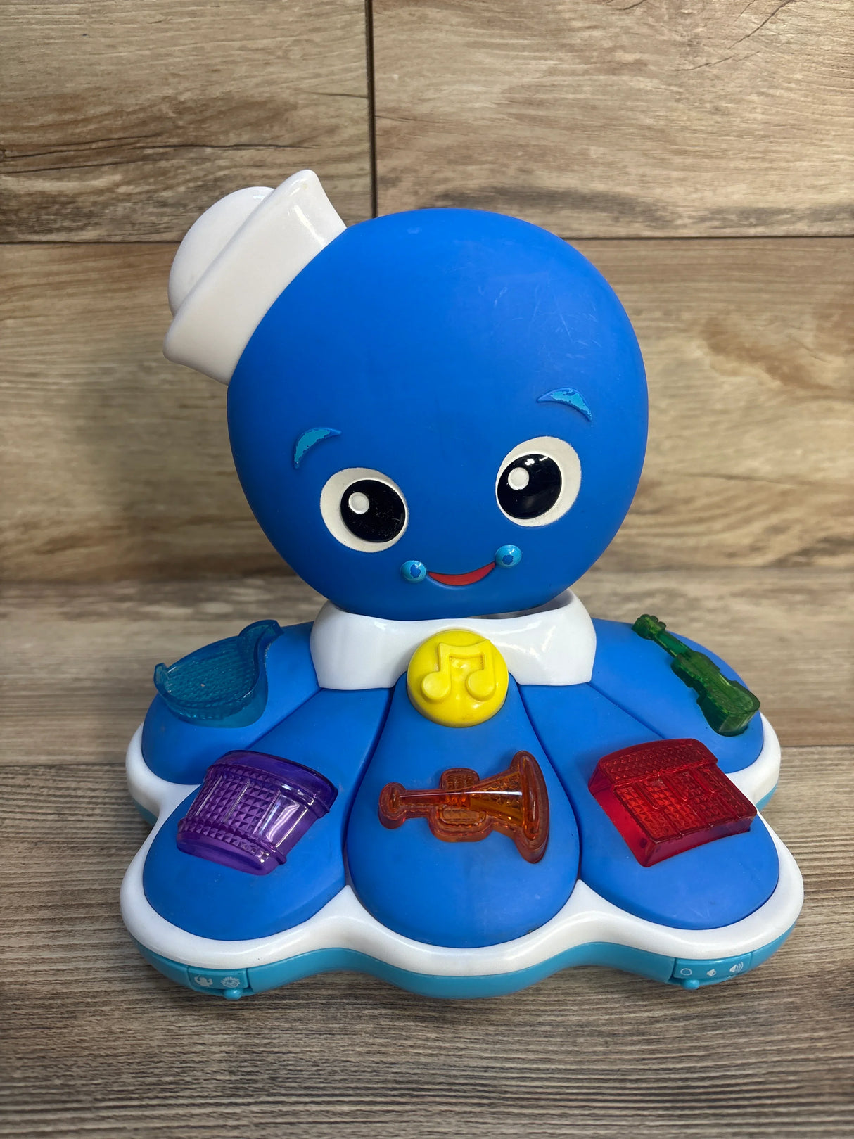 Blue octopus musical toy with colorful instrument buttons on wood floor