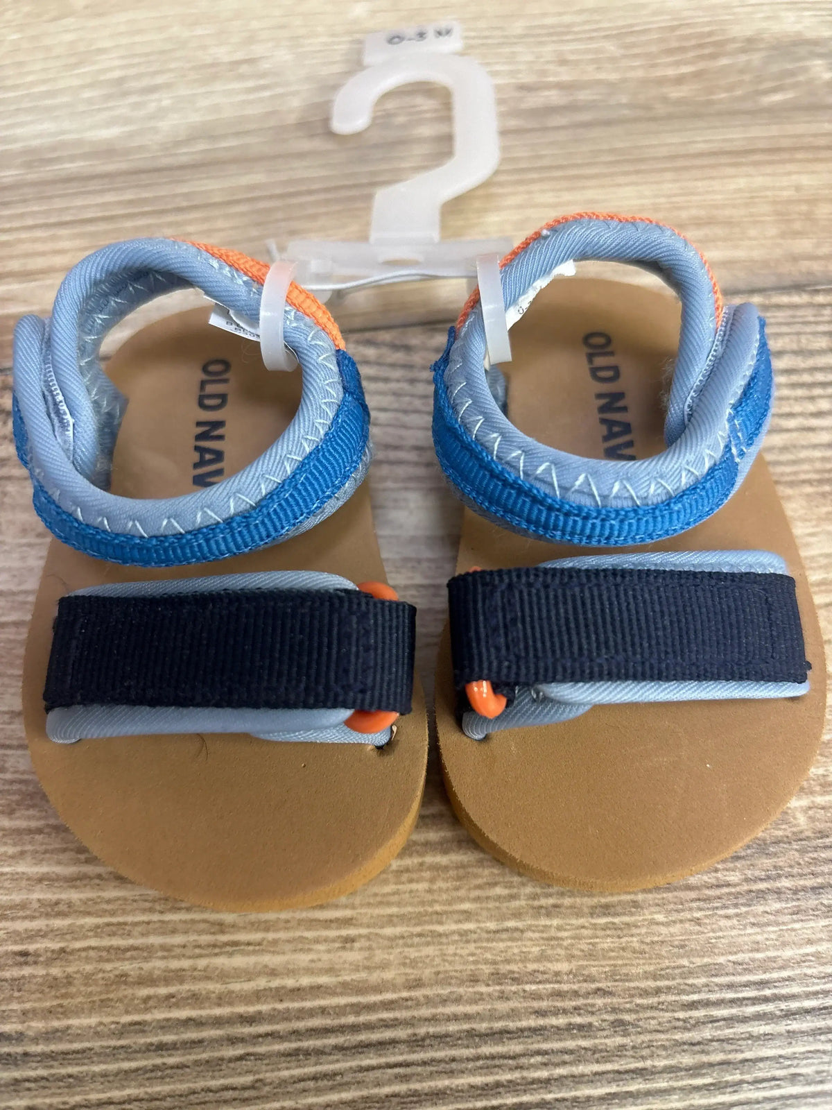 Top view of Wonder Nation Sports Slides in black, size 5C, showcasing open-toe slip-on straps on a wood surface