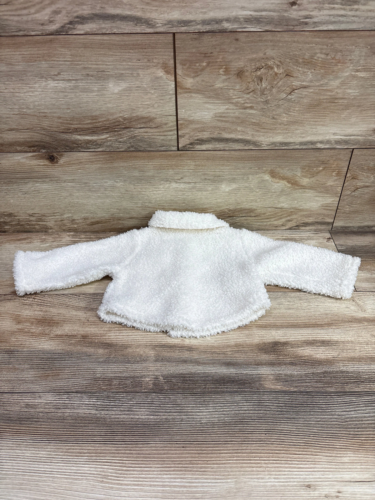 Ivory Shein embroidered sherpa button-up jacket for infants size 3-6m on a wood background