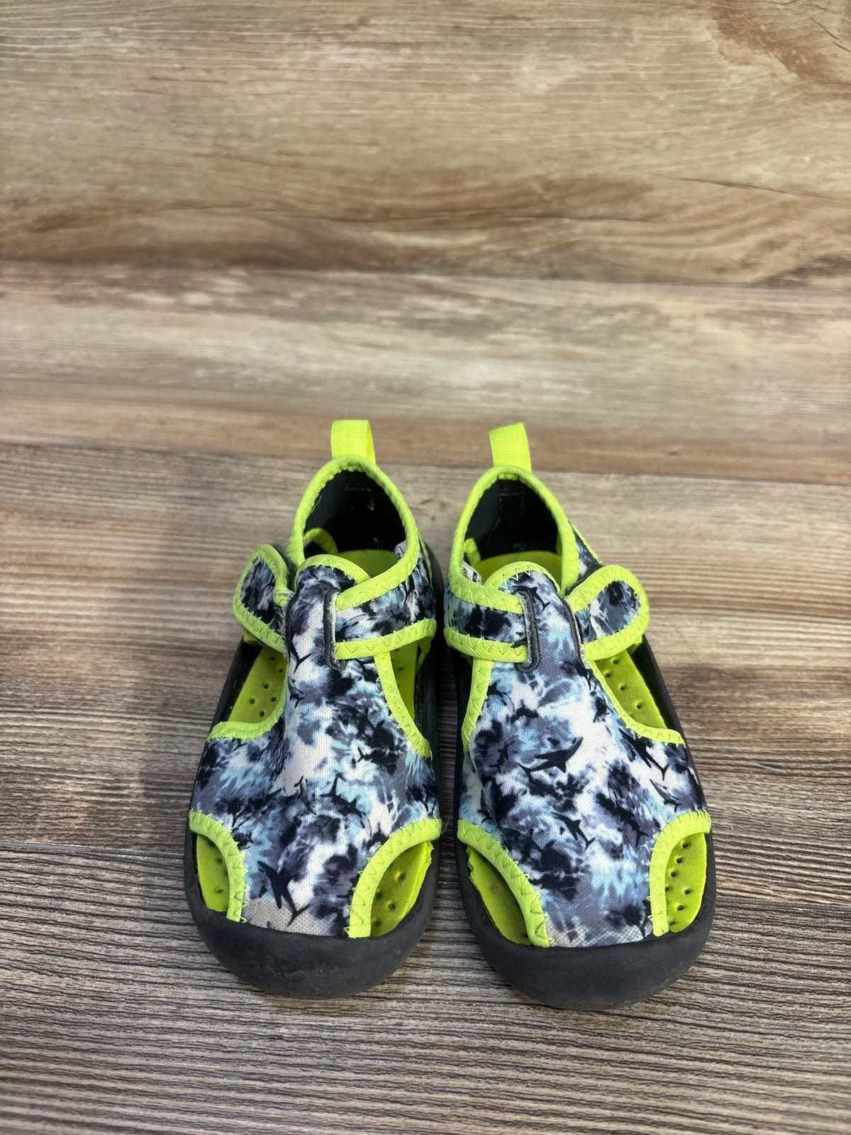 Front view of OshKosh Aquatic Water Shoes Grey/Green sz 7c showcasing hook and loop closure with a wood background