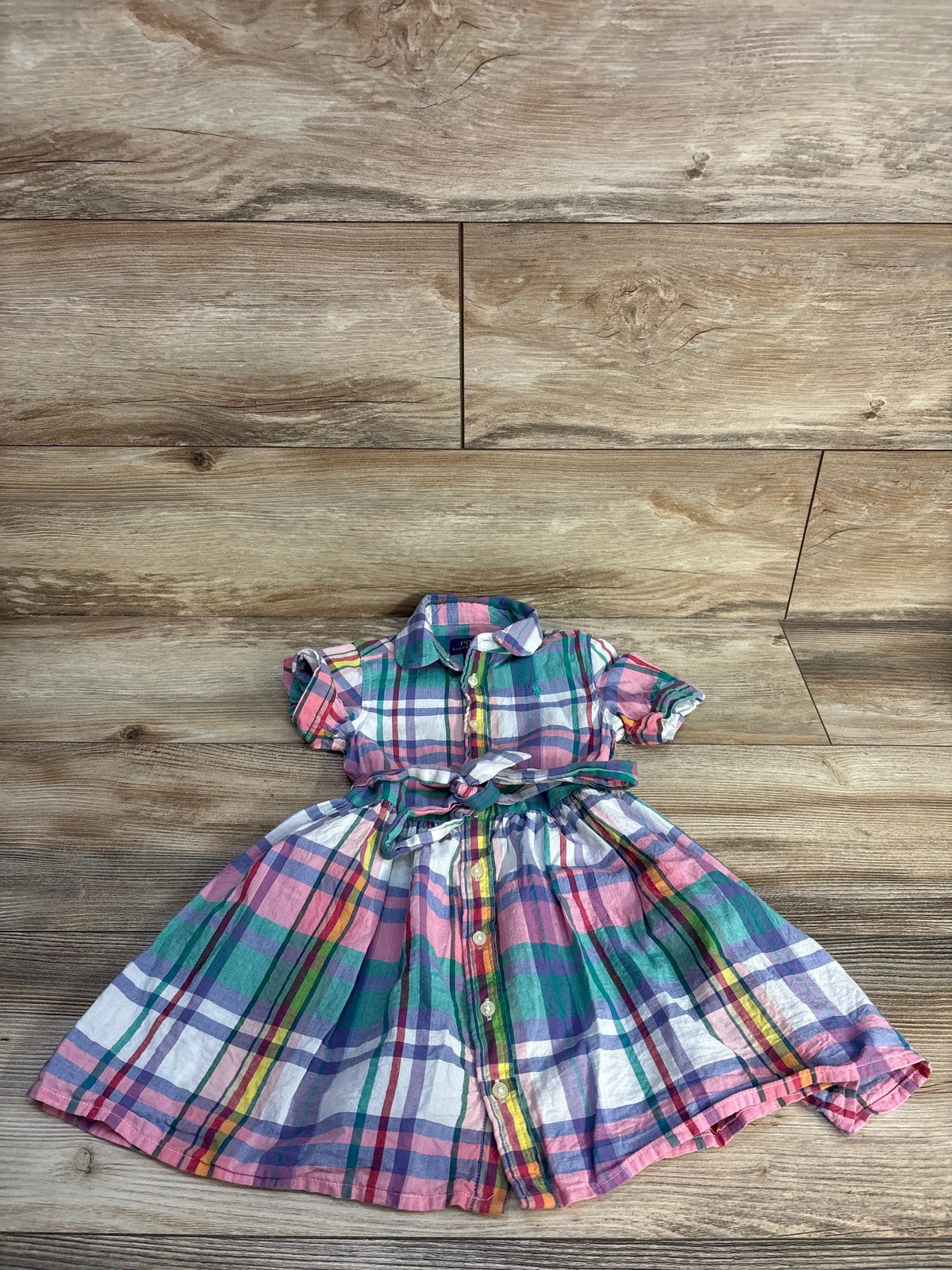 Front view of multicolor Polo Ralph Lauren cotton madras shirtdress showcasing plaid, button front on wood background