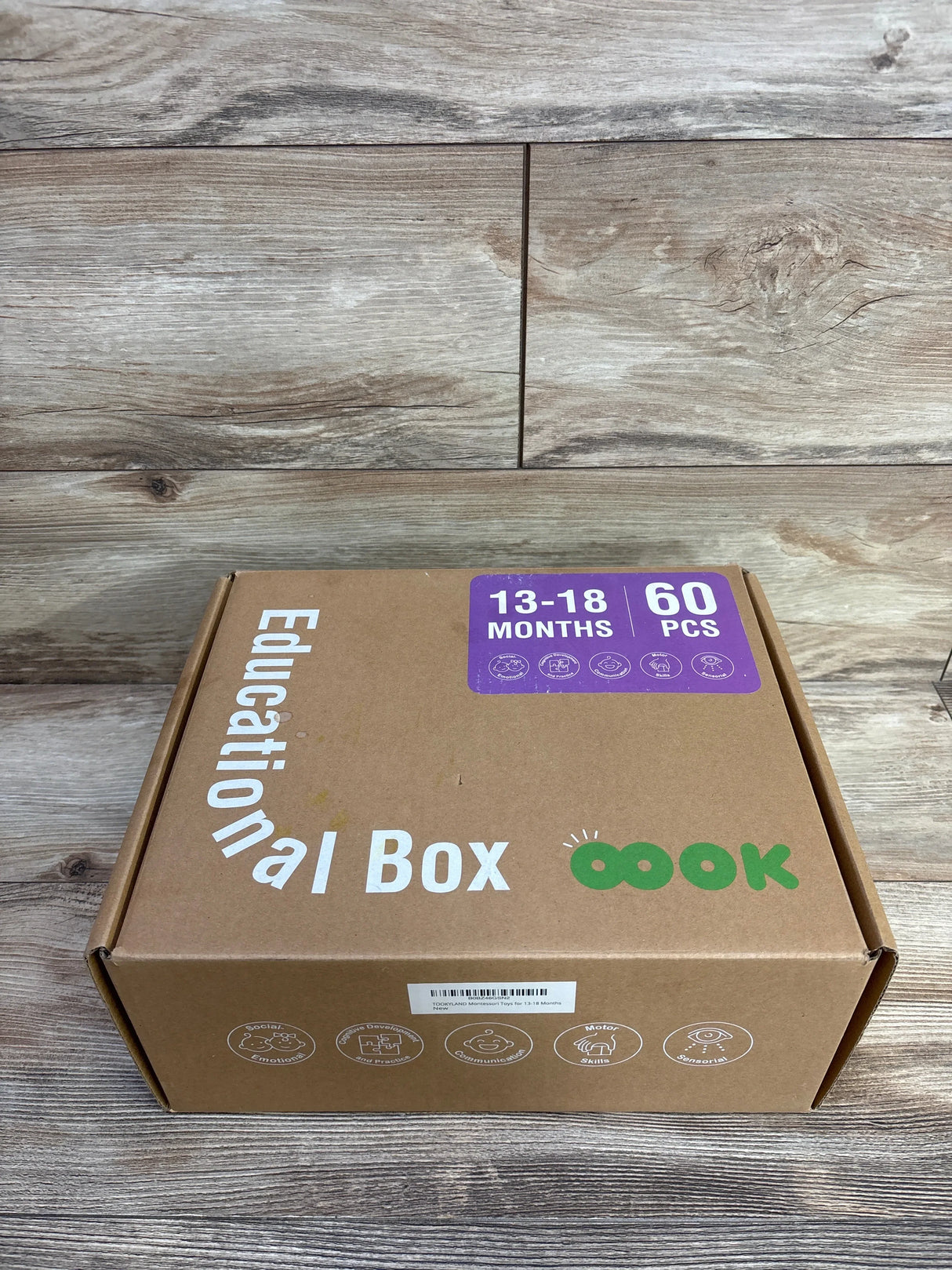 Front view of Tookyland Montessori Educational Toy Box showing 13-18 months, 60 pcs label on kraft box with wood background