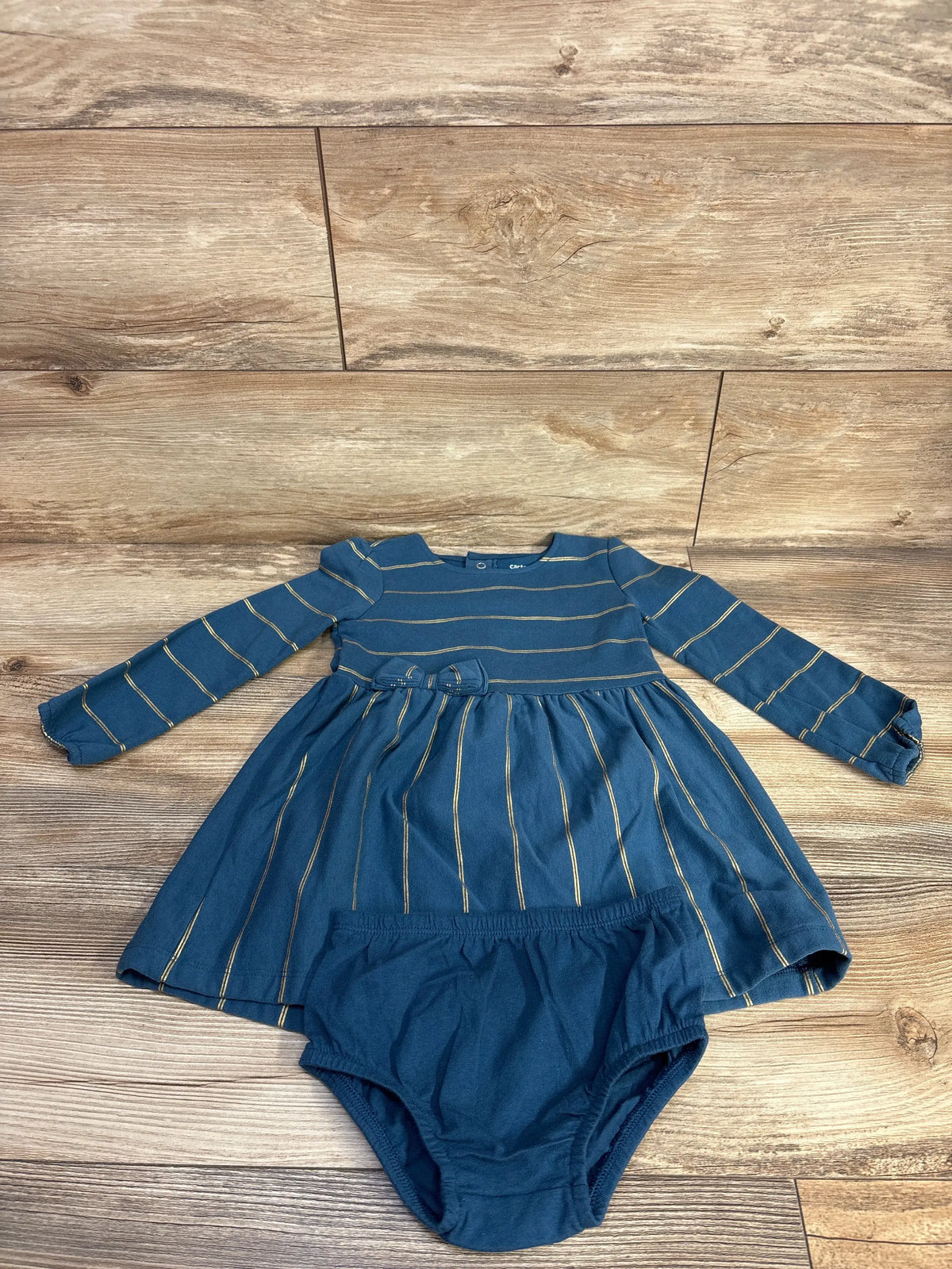 Front view of Carter’s blue striped dress and bloomers set showcasing long sleeves and matching bloomers on wood background