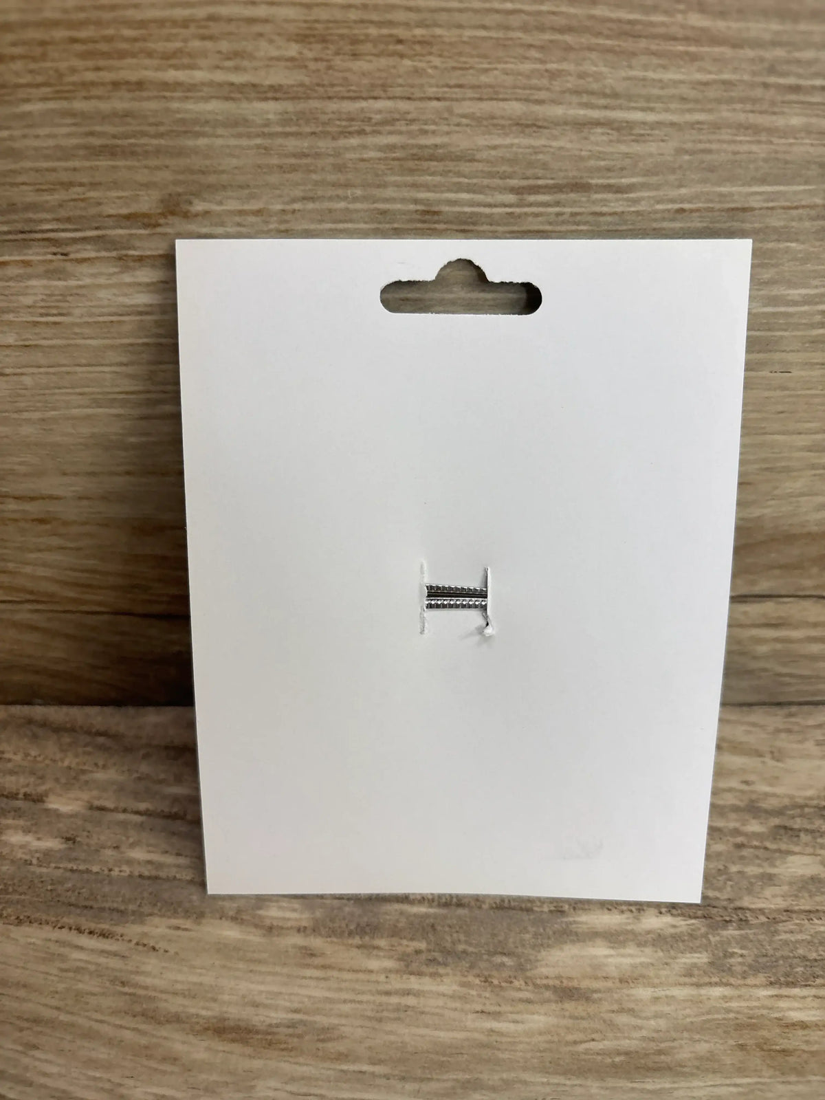 Back view of NEW Fourth of July Hair Bow showing its alligator clip on a white display card against a wood background
